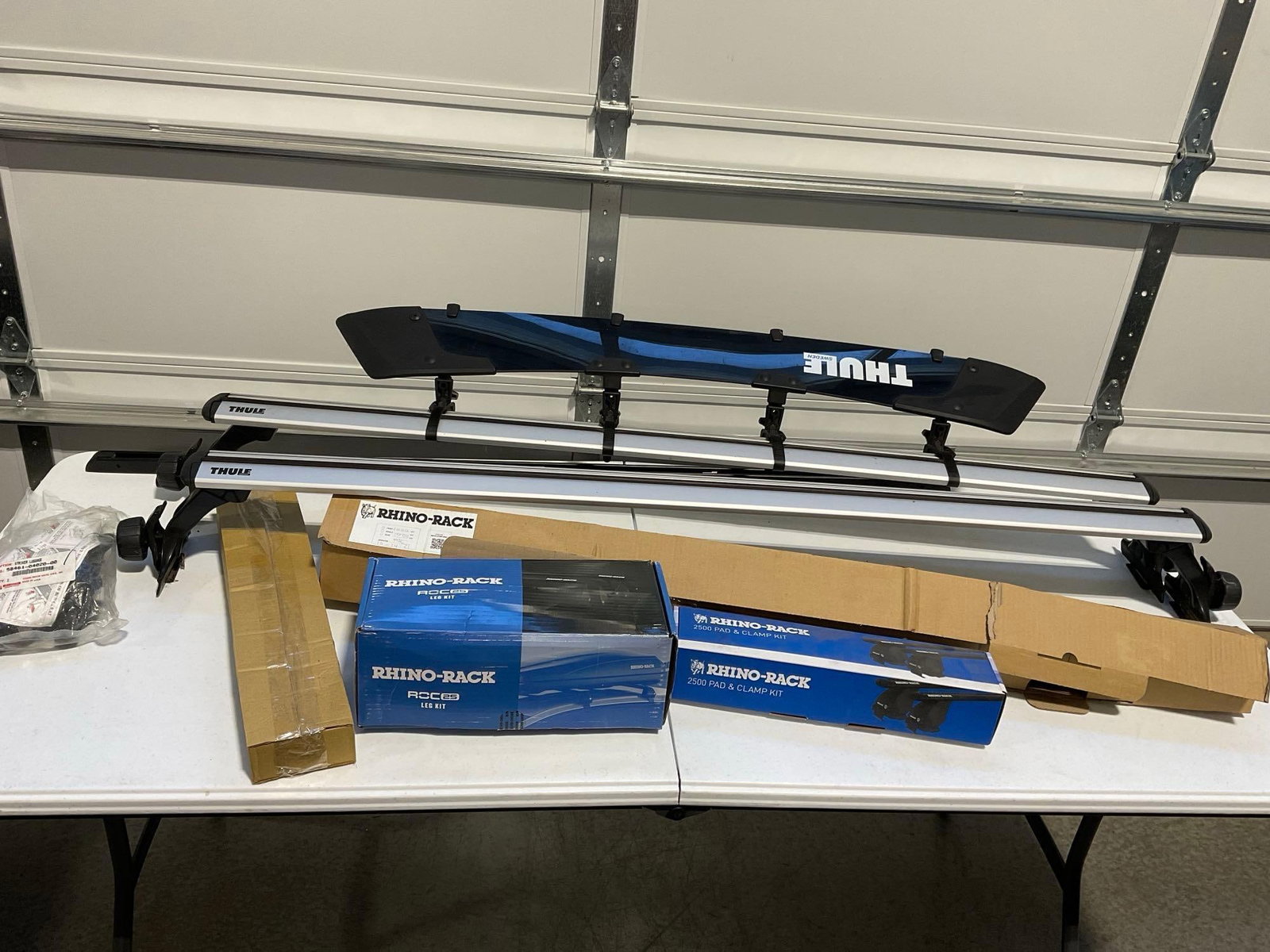 Pair of Roof Racks, Thule & Rhino-Rack, some in packaging, Roc 25 Legs, 2500 Pad & Clamp Kits: Appears to be in good shape.and unused The piece measures approx 13h x 64w x 17d inches. See pics. E-5910 *Freight Required if shipped, Buyer Arranged/Responsibility*