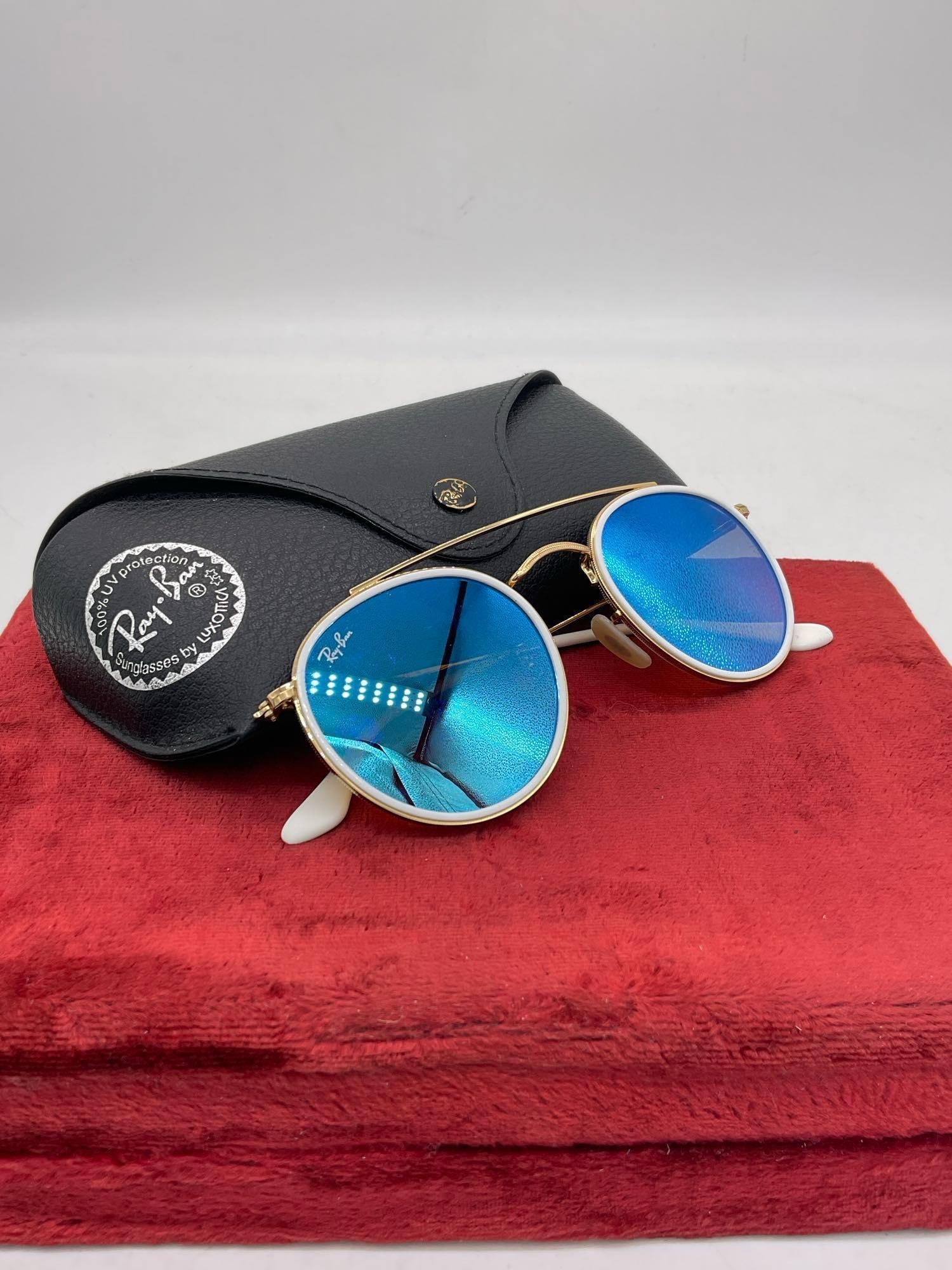 Pair of Ray-Ban RB3647N Round Double Bridge Unisex Polarized Sunglasses Gold toned & white frame: C-5910 Comes in OG Case The Ray-Ban RB3647N Round Double Bridge sunglasses, is a modern evolution of the classic round metal frame, distinguished by its unique double bridge and flat lenses. It f