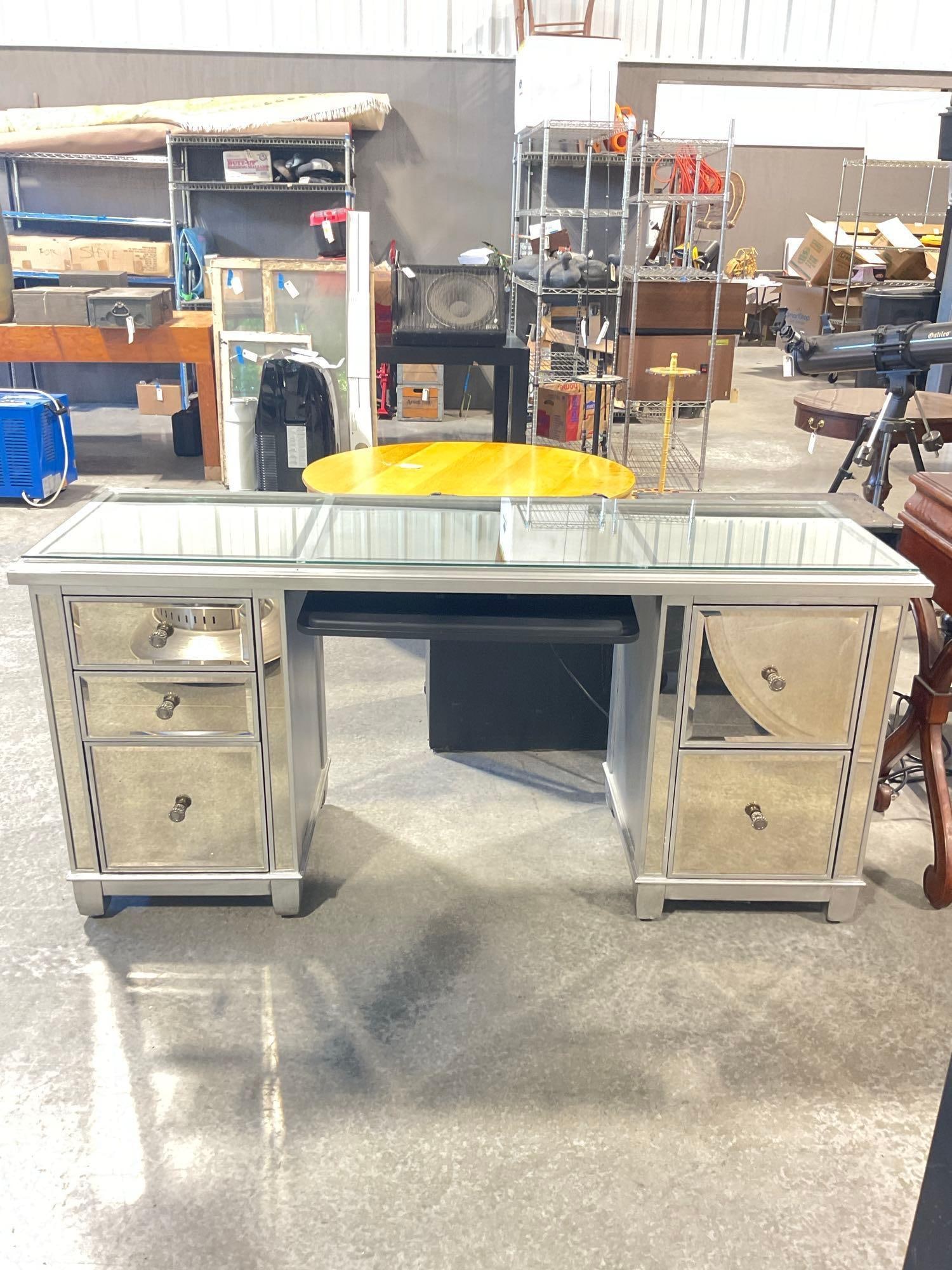 Modern Pier 1 Imports Mirrored silver writing / computer desk with additional glass top & tray: Approx 65" wide by 22" deep x by 31" high in good condition with no noticeable gaffes. Includes custom glass top put on by consignor and additional pullout keyboard tray. Freight required, no