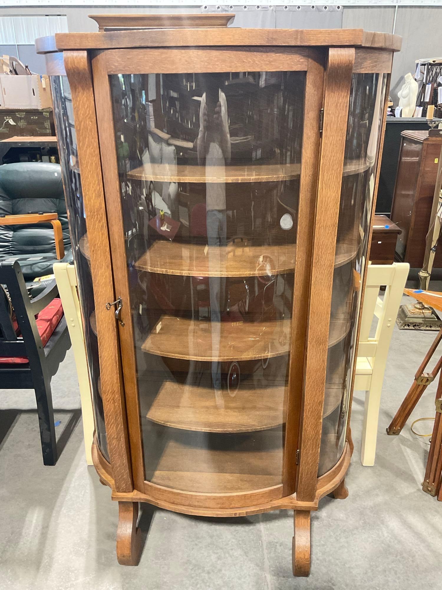 Antique K.C. Co. Tiger oak curved glass tri-panel curio cabinet with shelves and original tag: Approx 61" high by 15" deep by 36" wide. In fantastic condition for age, some minor wear on back panels, otherwise excellent. Has key and lock functions. Includes 4 shelves and glass is in good condit
