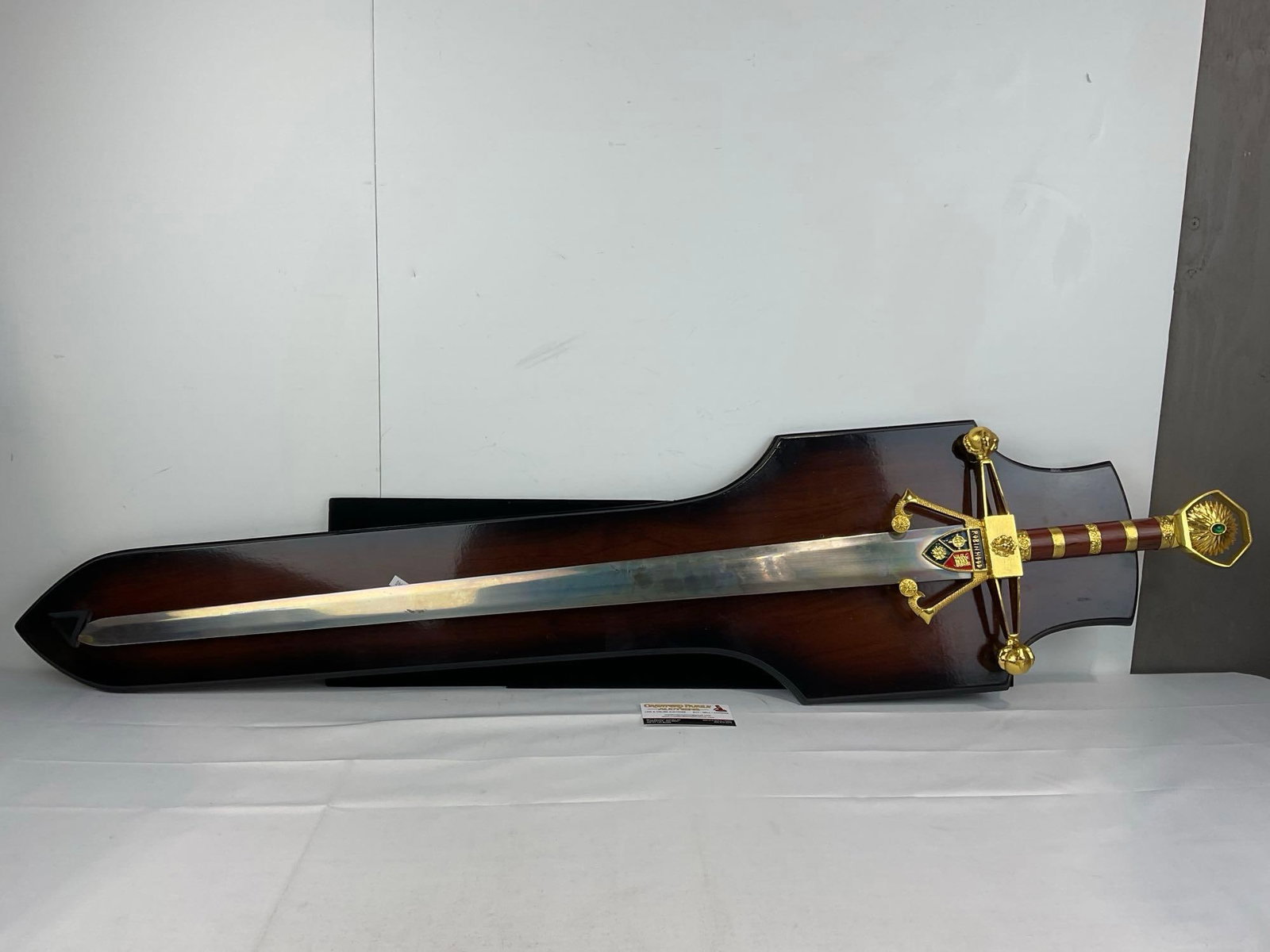 Decorative Fantasy Longsword Replica, marked Robin Hood, Brass & wood Handle49 inches long: Unsharpened blade, w/plaque holder. Some wear from storage. Appears to be in good shape. The piece measures approx 49h x 12w x 4d inches. See pics. E-5940 *Oversized shipping may apply*