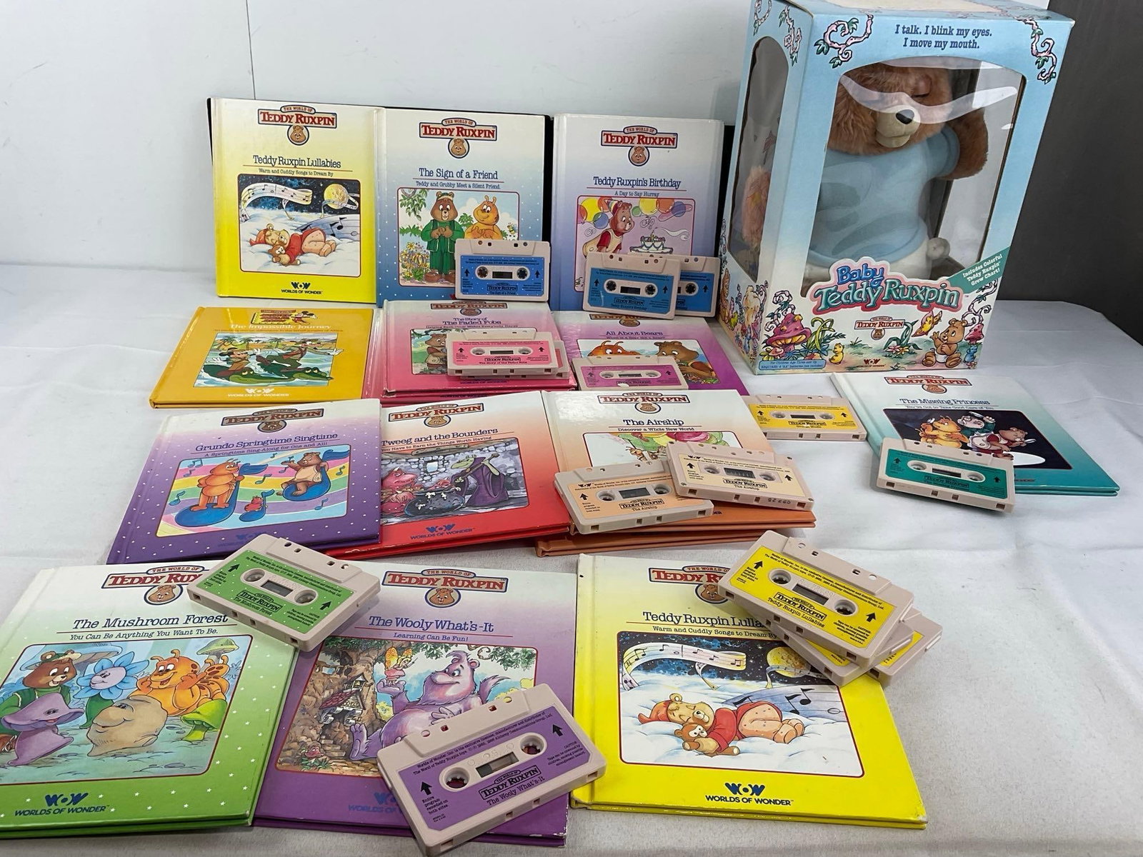 Teddy Ruxpin Storybooks, w/14 cassettes, & Baby Teddy Ruxpin toy in box: Appears to be in fair to good shape, the electronics are untested, assumed working. The piece measures approx 13h x 24w x 17d inches. See pics. E-5950