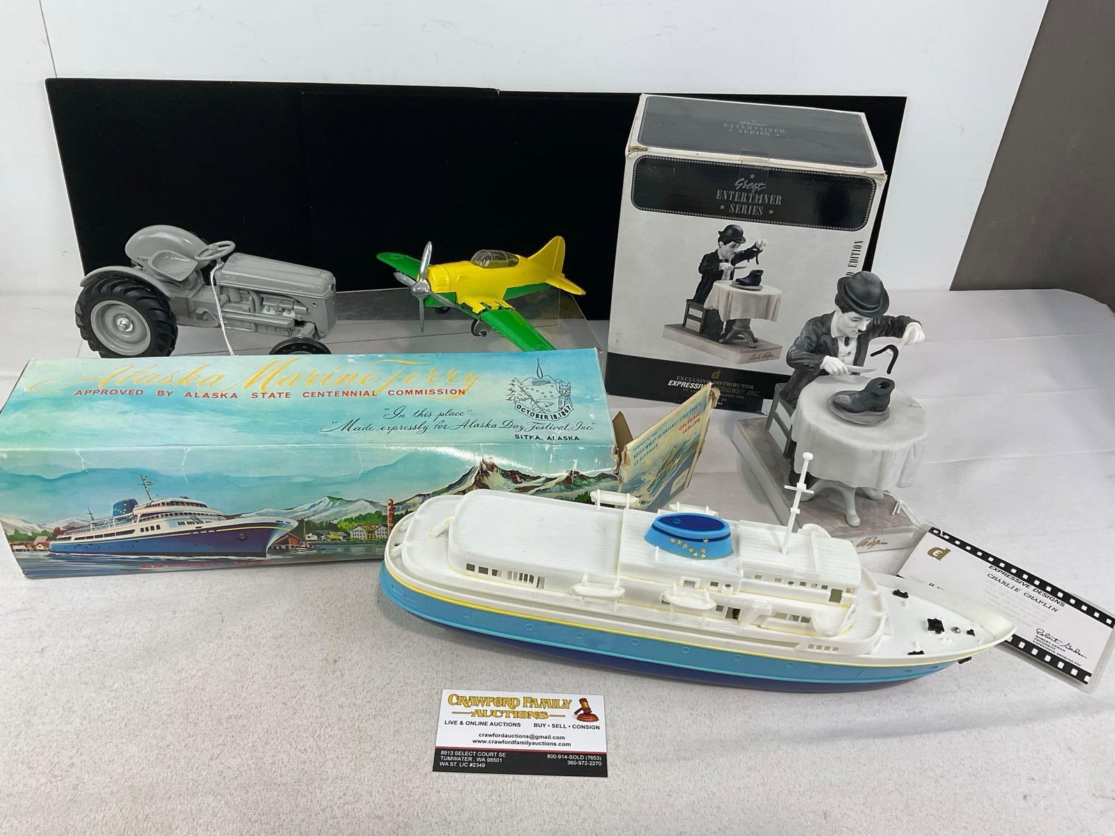 Alaska Marine Ferry, Hubley Folding Plane, 1985 Ford 9N Tractor, Charlie Chaplin Porcelain Statue: Appears to be in good shape, some shelf wear to the boxes. The piece measures approx 6h x 17w x 14d inches. See pics. E-5950