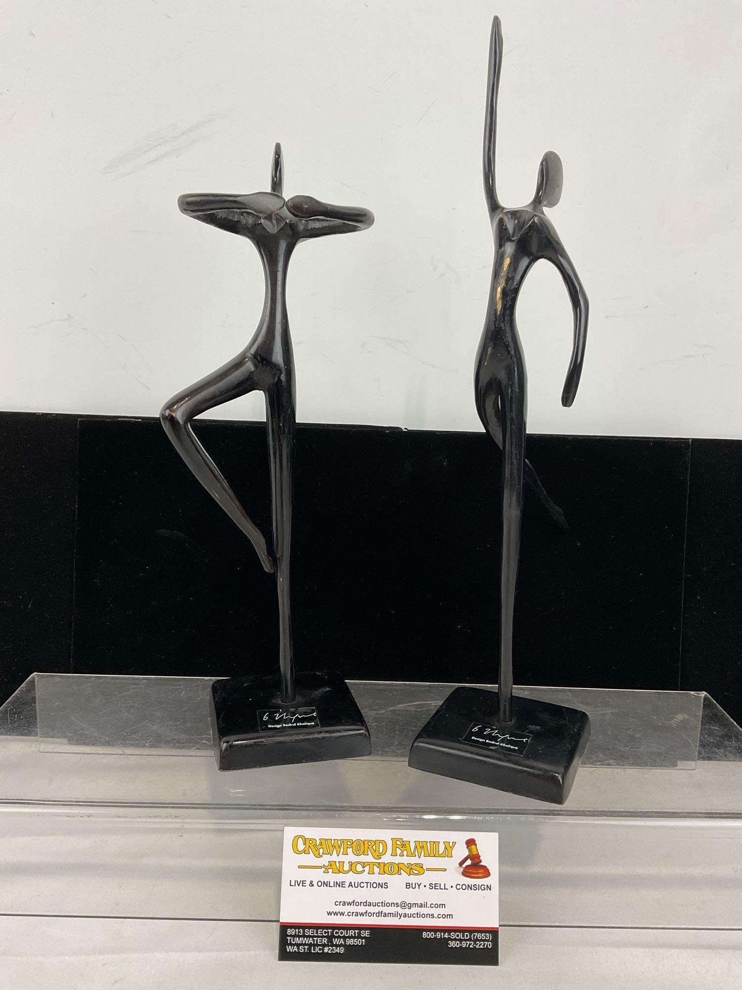 Pair of Design Bodrul Khalique Cast Brass Figures, dark finish on top, 14 inches tall: Appears to be in good shape, some scratches on the finish revealing the brass underneath. The piece measures approx 14h x 7w x 4d inches. See pics. E-6080