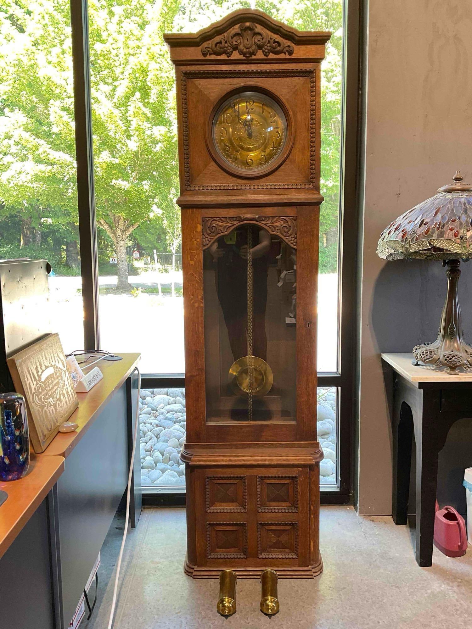 Antique Universal Grandfather Clock in Carved Oak Wood Case, incl. Pendulum & Weights.: Antique Universal Grandfather Clock in Carved Oak Wood Case, incl. Pendulum & Weights. Could be German? Looks to be missing back panel, dial looks to be repaired?, otherwise looks to be in good co