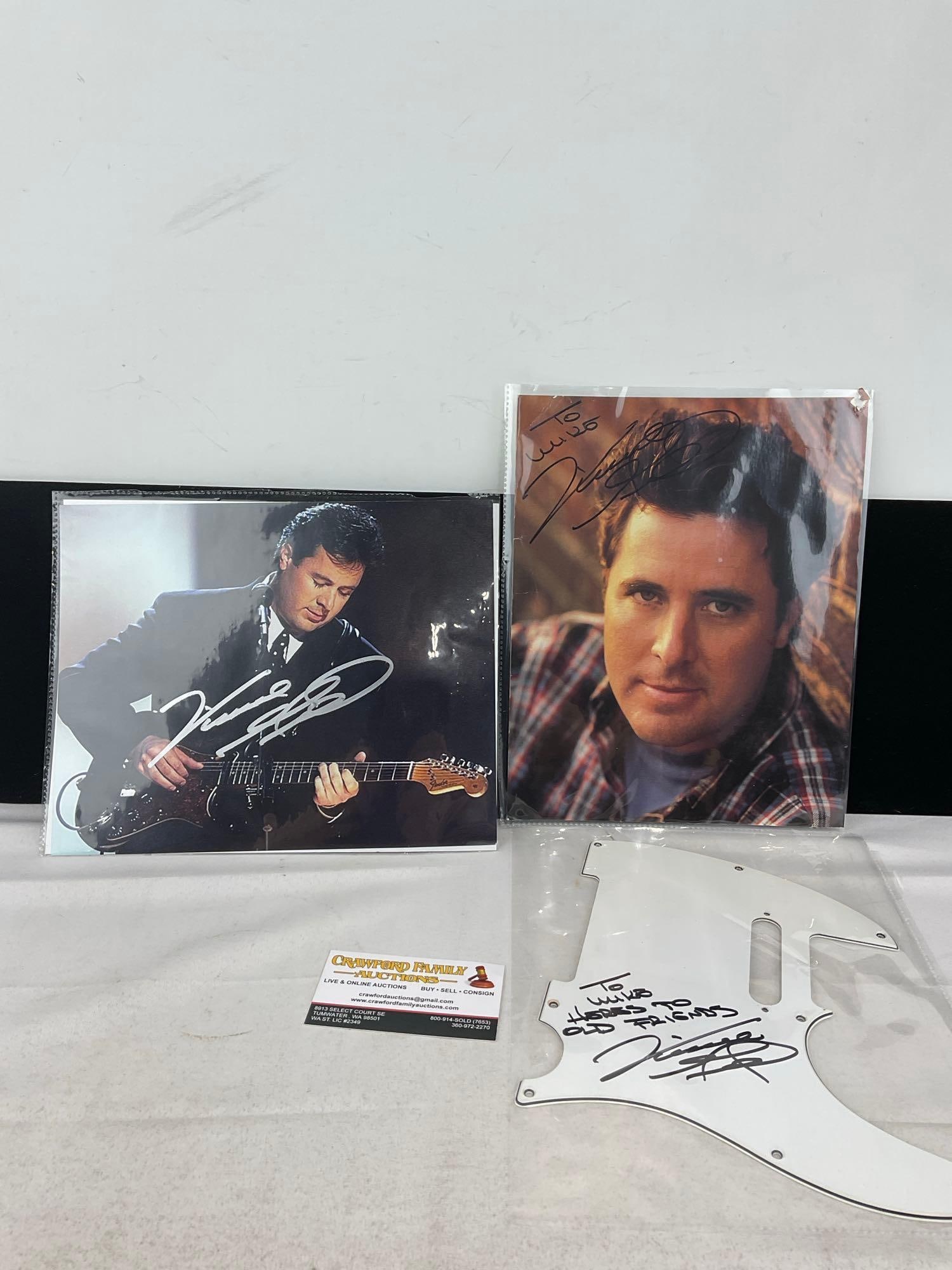 Pair of Signed Photographs of Vince Gill & Personalized Fender Strat guitar Pickguard: This from the collection of the late owner of a Collection Store. The pickguard says To Mike Heres to Old Friends. Appears to be in good shape. The piece measures approx 11h x 9w x 2d inches. See