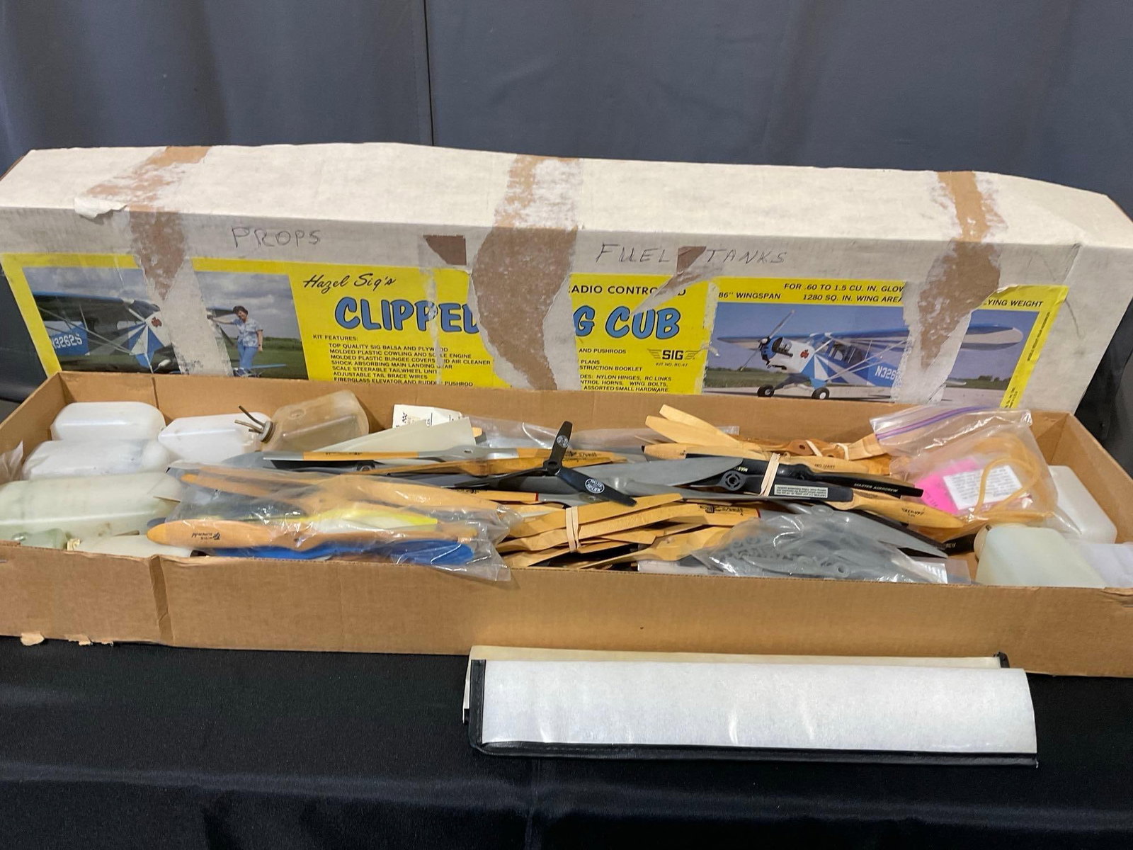 Box of RC Airplane parts, 35-40+ Propellers, several Fuel Tanks, & more pieces, see pics: The plane models included engines that were working 1+ years ago. All from the same collection. Appears to be in good shape. The piece measures approx 6h x 46w x 13d inches. See pics.