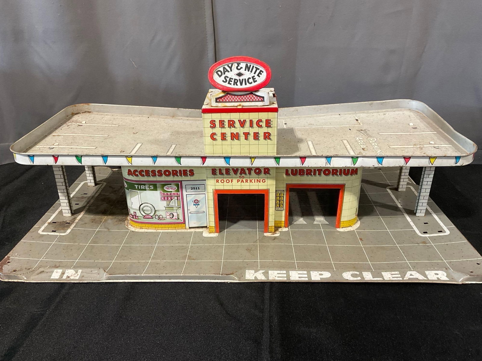 Vintage 1950s Louis Marx & Co Day & Nite Service Center Tin Litho Diorama, 12x27x16 inches: Appears to be in fair to good shape. The piece measures approx 12h x 27w x 16d inches. See pics. E-6300