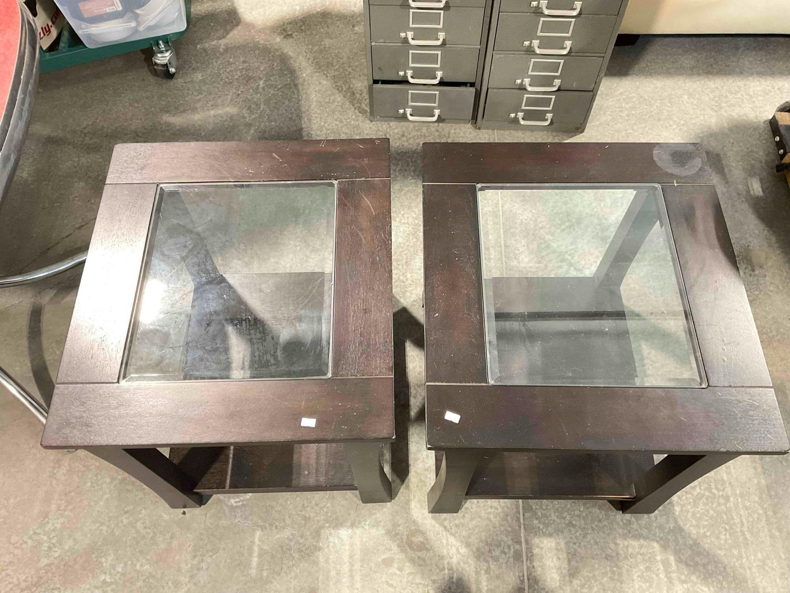 2 pcs Modern 2-Tier Glass Topped Wooden Side Tables w/ Dark Brown Finish. Fair Condition.: 2 pcs Modern 2-Tier Glass Topped Wooden Side Tables w/ Dark Brown Finish. Fair Condition. Pieces have wear indicative of age and use, veneer is stained and peeling in places, otherwise look to be in f