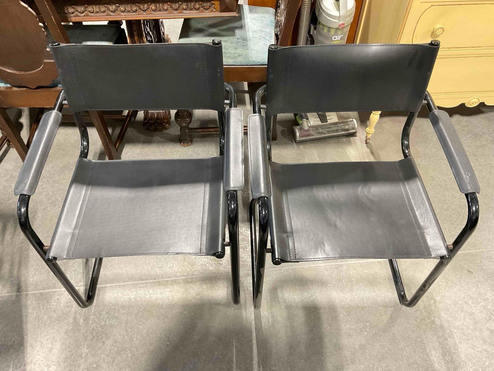 Pair of Black Metal & Faux Leather Cantilever Chairs. Fair Condition. Measures 24" x 21" x 32": Pair of Black Metal & Faux Leather Cantilever Chairs. Fair Condition. Measures 24" x 21" x 32" pieces have wear indicative of age and use, otherwise looks to be in fair condition. DM-414 