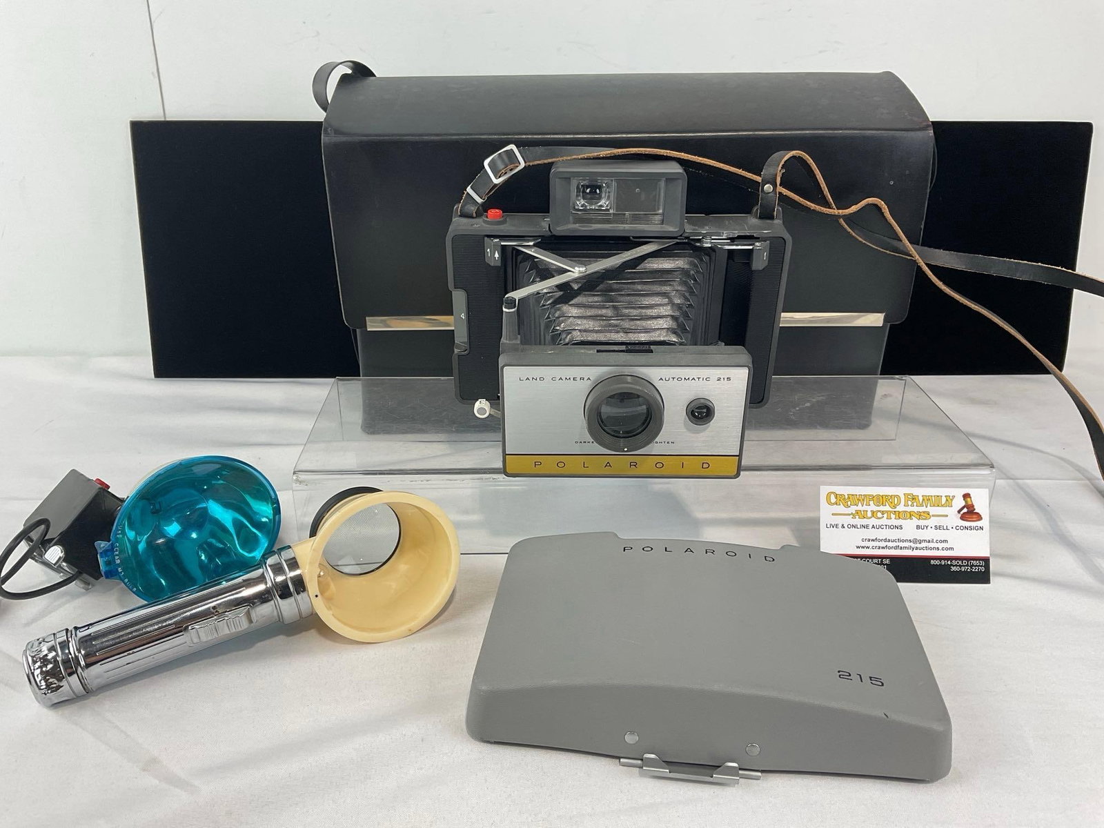 Polaroid Land Camera Automatic 215, w/Leather Case, 2 Flash modules: Appears to be in good shape. The piece measures approx 10h x 15w x 7d inches. See pics. E-6610