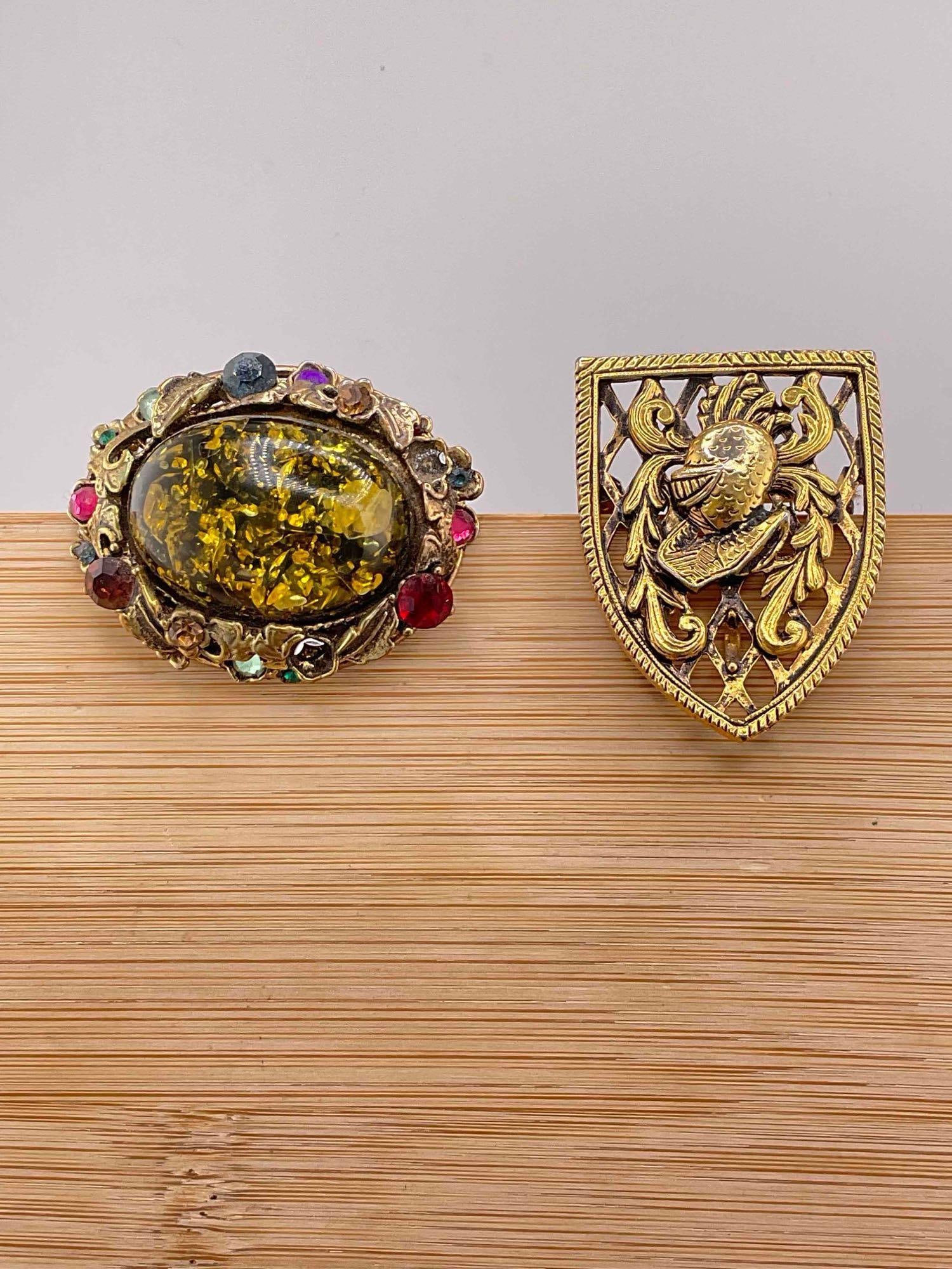 2x Vintage brooches Alucraft Heraldic Shield & Filigree setting Multi-Colored RhineStone chantons: C-6110 The Rhine stone brooch appears to be missing 2 stones, center is a oval confetti style setting.