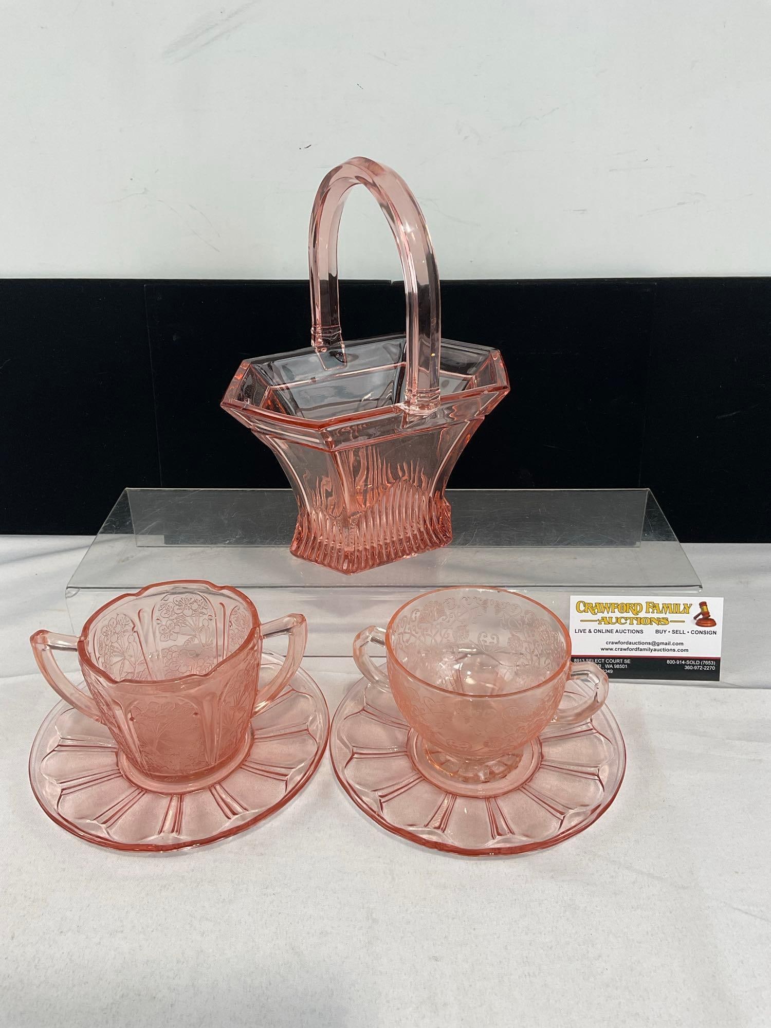 Heisey Pink Depression Glass Basket, 2 Hazel Atlas Double Handled Cups & 2 Anchor Hocking Saucers: The basket has a small chip near the handle. Another chip on the bottom of one of the cups/sugar bowls. See pics for condition. Measures approx 11h x 8w x 7d inches. E-6610