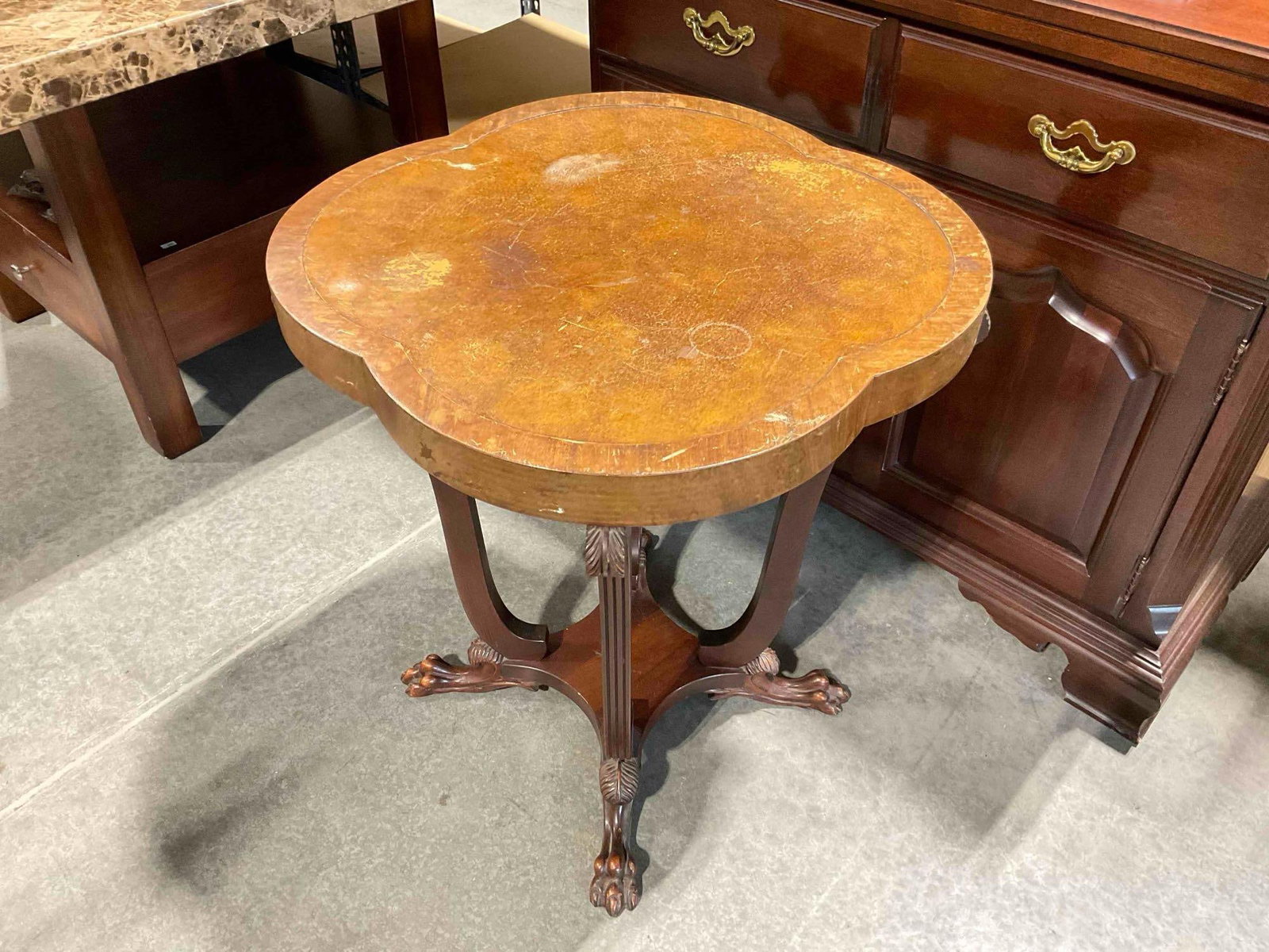 Vintage Quatrefoil Accent Table w/ Carved Wooden Base, Handsome Feet & Leather Inset Top.: Vintage Quatrefoil Accent Table w/ Carved Wooden Base, Handsome Feet & Leather Inset Top. Piece has heavy wear indicative of age and use, top is scraped and worn, base is stained, see photos for c