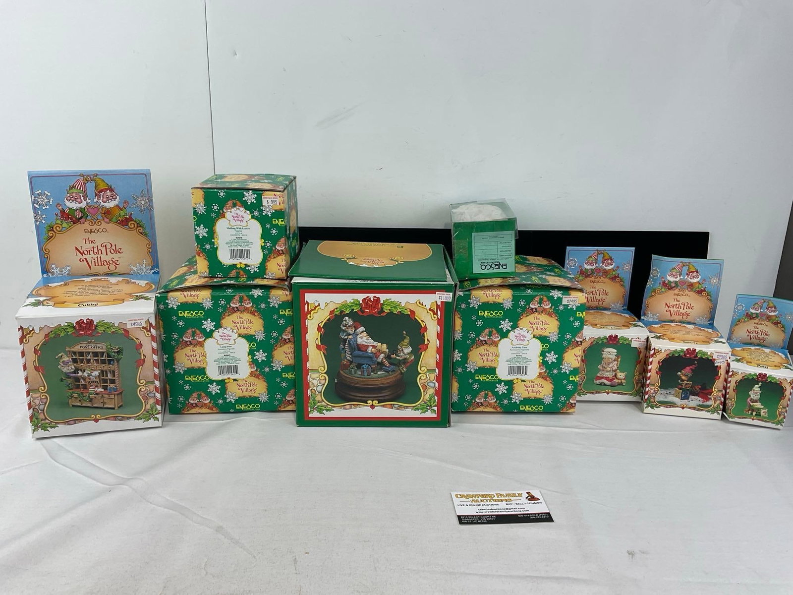 9 Enesco The North Pole Village Figurines in box: Unchecked for wear. See pics for condition. Measures approx 10h x 25w x 15d inches. E-6670