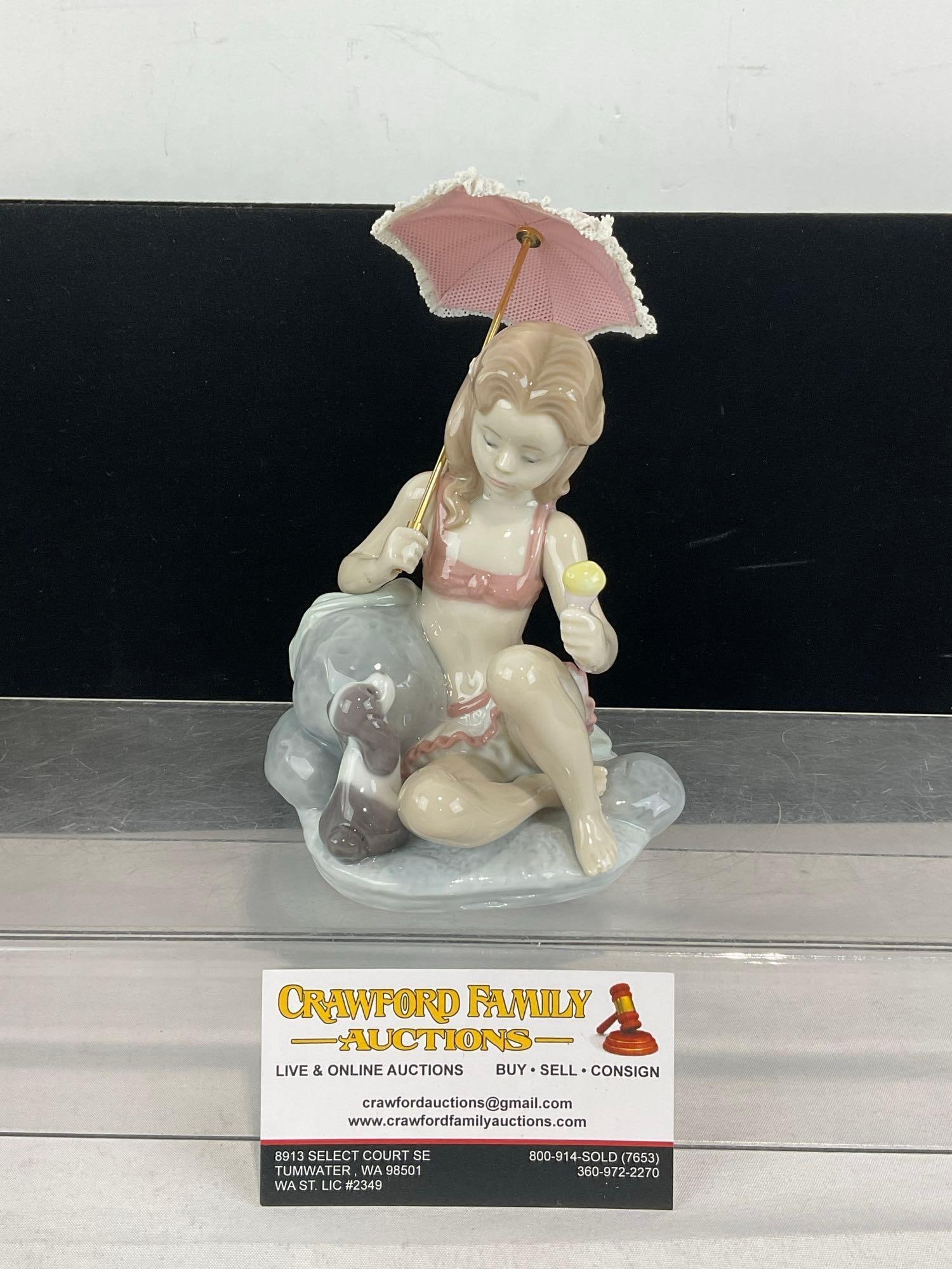 LLADRO Glazed Porcelain Figurine in box, #06012 Mondays Child, 8h x 5w x 4d inches: Last Retail 290 dollars. Issued 1993, and retired in 1997. Comes with the fragile bisque porcelain umbrella piece w/brass screw on handle. See pics for condition. The box measures approx 6h x 12w x 6d