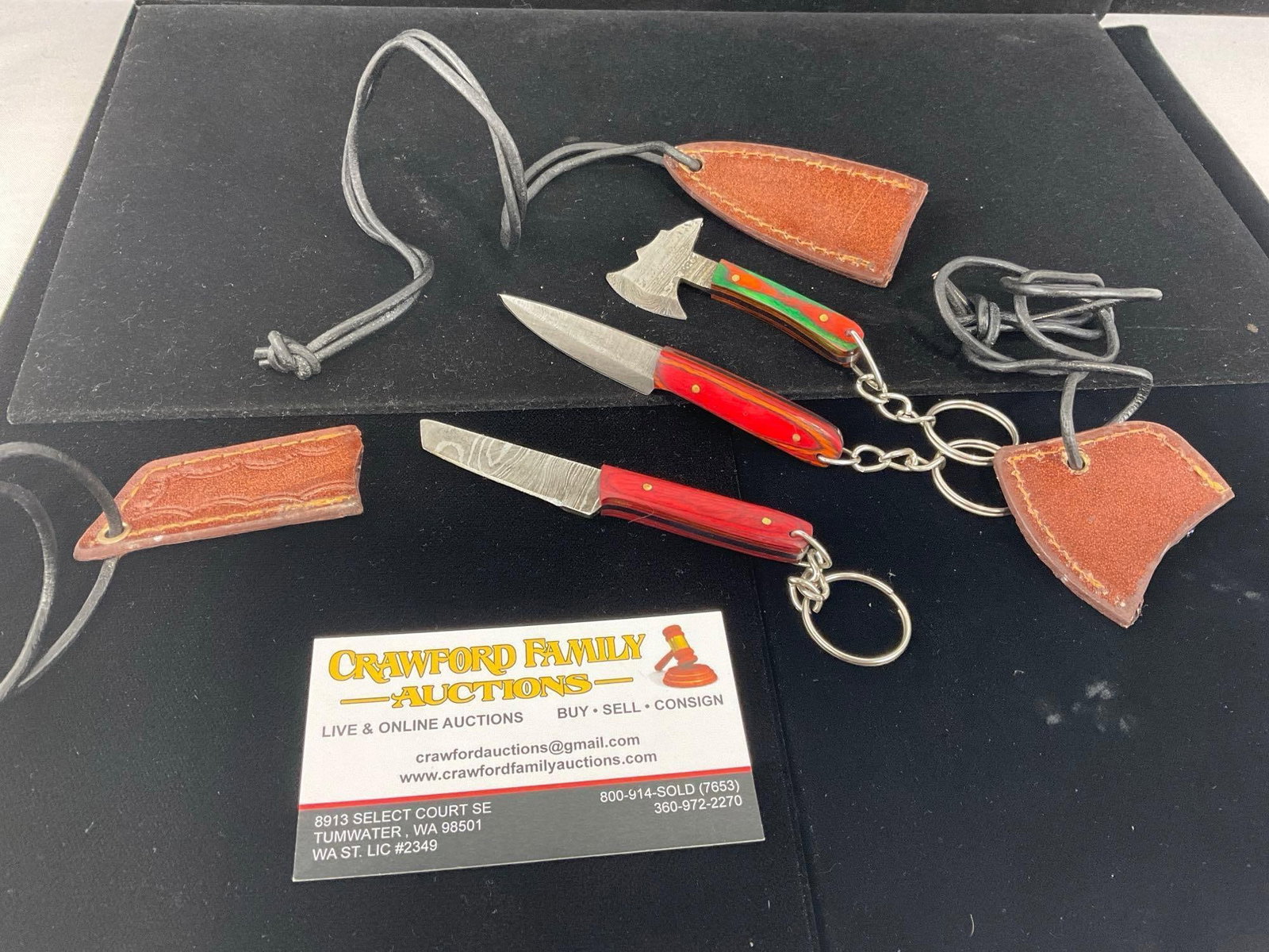 3 Keychain size Damascus Knives, w/Leather Sheaths, tinted wood handles: All these knives are from the same collection. See pics for condition. Measures approx 5h x 4w x 2d inches. E-3440