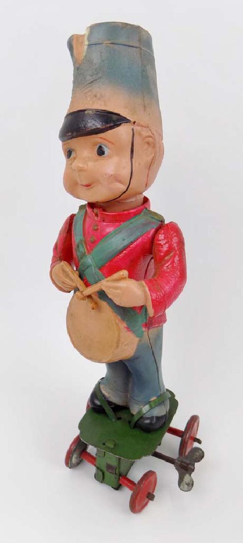 CELLULOID DRUMMER BOY: AN EARLY CELLULOID DRUMMER BOY WIND UP TOY MEASURING 9"T.