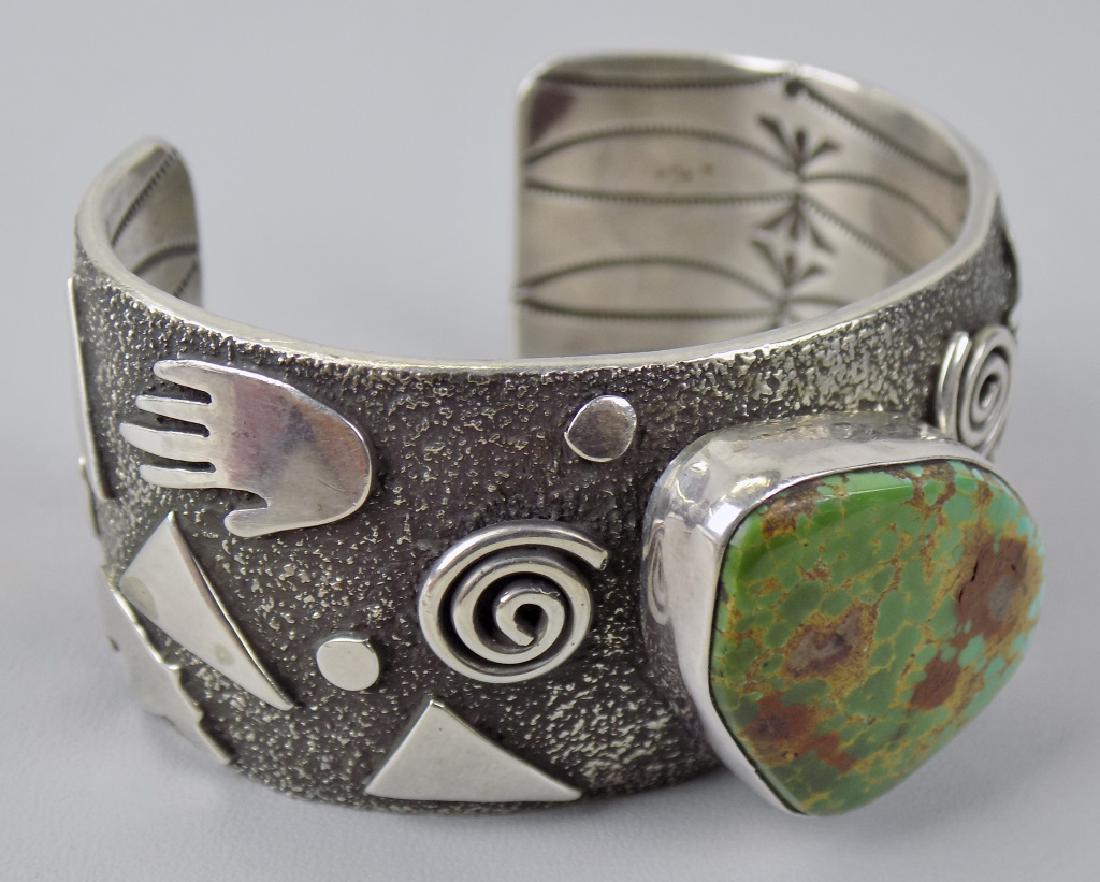 S-WESTERN STERLING & GREEN TURQ. CUFF BRACELET: SIGNED ALEX SANCHEZ, NAVAJO. WITH INDIAN SYMBOLS AND DESIGN INSIDE. SIZE 6-1/2", 1" WIDE.