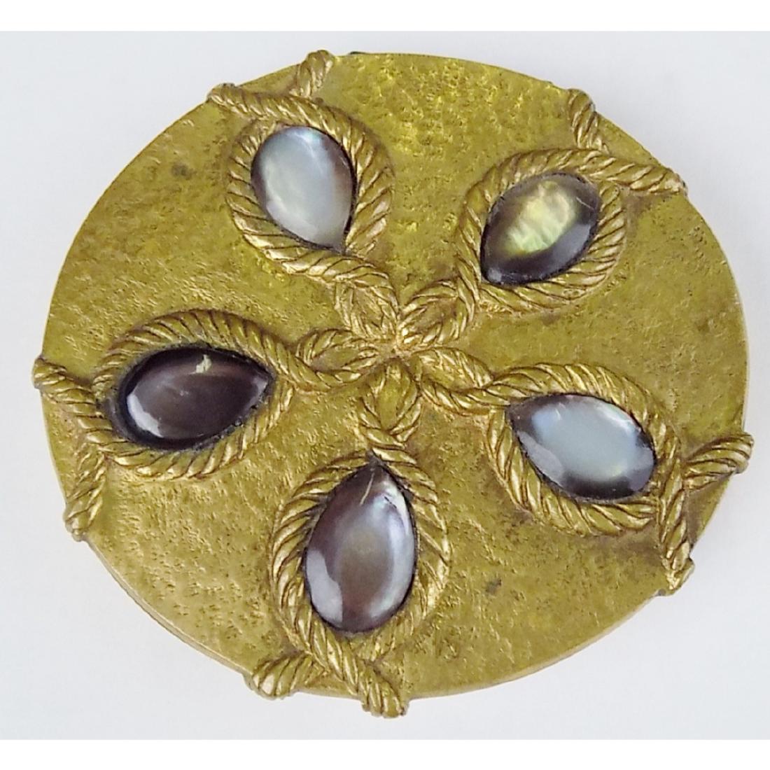 LINE VAUTRIN COMPACT: A SOLID BRASS SIGNED LINE VAUTRIN FRANCE COMPACT. DECORATED WITH BRASS TWISTED ROPE DECORATION AROUND MOTHER OF PEARL STONES. MEASURES 3.25" DIAMETER.