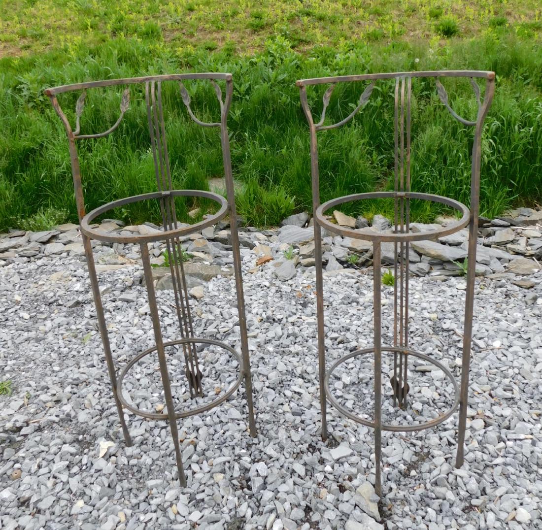 SIBERIAN WROUGHT IRON STOOLS: A PAIR OF ROUND SIBERIAN WROUGHT IRON STOOLS WITH LEAF AND BRANCH DECORATION. MEASURES 46"H X 13"W X 18"D. FLOOR TO SEAT HEIGHT IS 32"H.