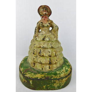 BONNET DRESS CAST IRON LADY DOORSTOP: A CAST IRON FIGURAL DOORSTOP. LADY IN BONNET DRESS. MEASURES 5.25"H X 4.5"W X 3.75"D.