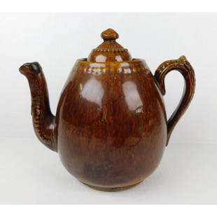BENNINGTON STONEWARE TEAPOT: A BENNINGTON BROWN STONEWARE TEAPOT WITH LID. MEASURES 8.5"H X 11"W.