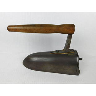 UNUSUAL SAD IRON: AN UNUSUAL CAST IRON SAD IRON WITH WOODEN HANDLE.