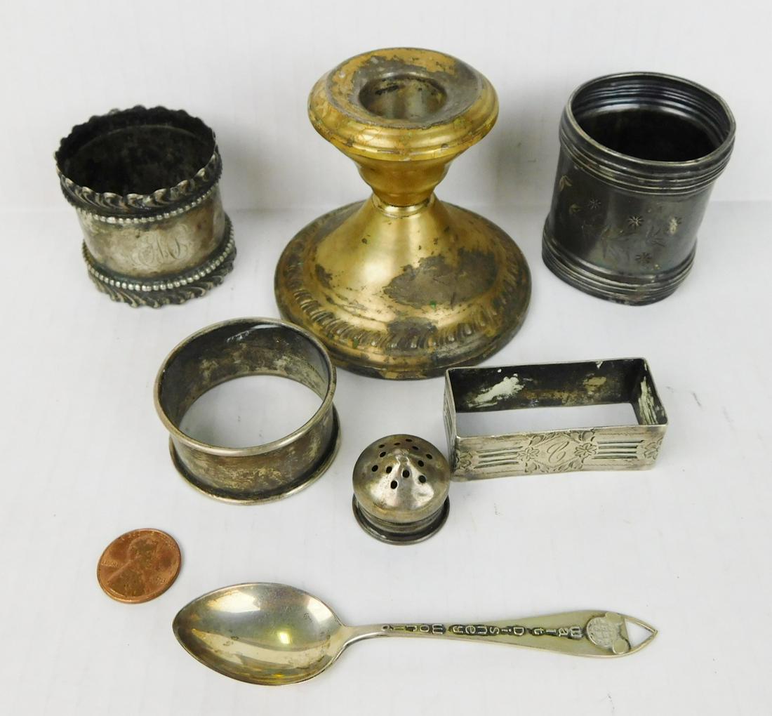 ASSORTED STERLING LOT: A LOT OF ASSORTED STERLING ITEMS. ITEMS INCLUDE AND WALT DISNEY WORLD SPOON, SHAKER TOP, NAPKIN RINGS, AND WEIGHTED CANDLESTICK. TOTAL WEIGHT WITHOUT CANDLESTICK IS 113.6 GRAMS.
