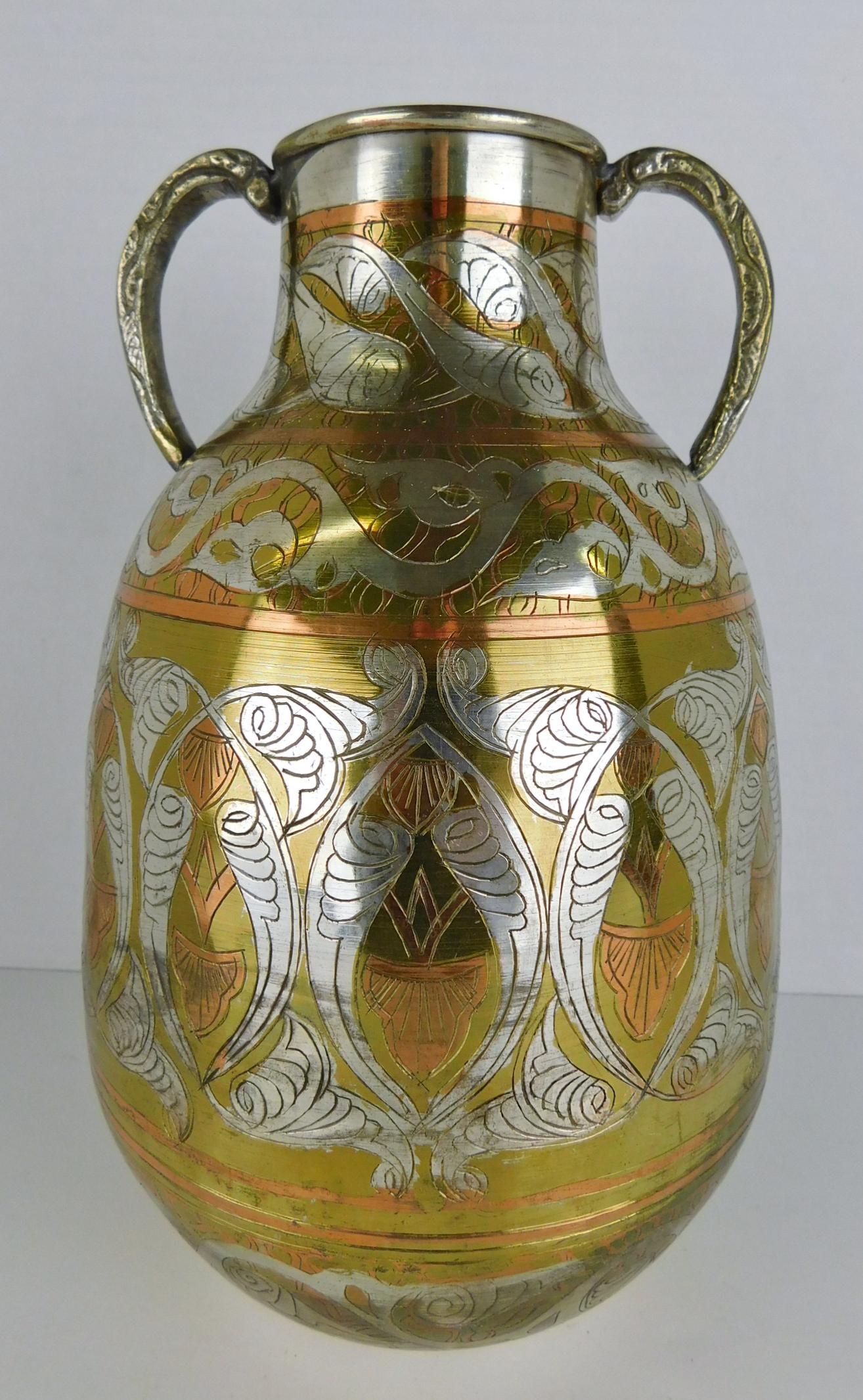 DECORATED TWO HANDLED JUG: A DECORATED TWO HANDLED JUG. COPPER, BRASS, AND POLISHED METAL. EMBOSSED DECORATIONS THROUGHOUT. MEASURES 10.5"H.