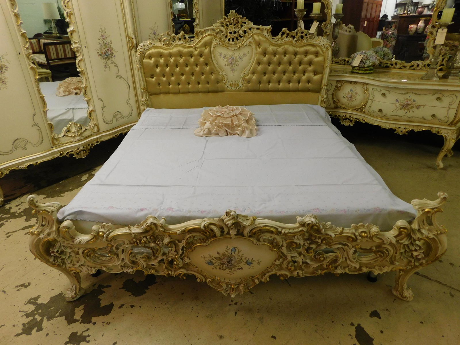QUEEN FRENCH PROVENCIAL CARVED BED: A HEAVILY CARVED FRENCH PROVINCIAL STYLE QUEEN SIZED BED. CARVED TUFTED HEADBOARD WITH FLORAL CENTER DECORATION AND CARVED FOOTBOARD WITH CENTER FLORAL DECORATION. BOX XPRING AND MATTRESS ARE INCLUDED