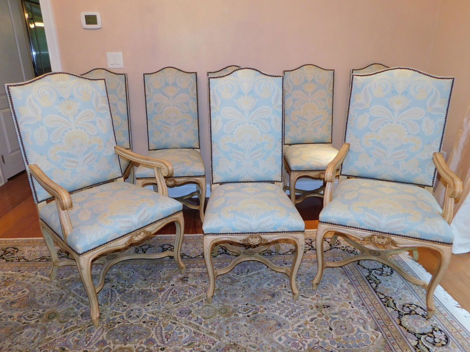 EIGHT UPHOLSTERED DINING CHAIRS: A LOT OF EIGHT UPHOLSTERED DINING CHAIRS. TWO CARVED ARM CHAIRS AND SIX CARVED SIDE CHAIRS. PLEASE SEE PHOTOGRPAHS. SIDE CHAIRS MEASURE 19"W X 20"D X 44"H. ARM CHAIRS MEASURE 24"D X 23"W X 44"H. SEAT
