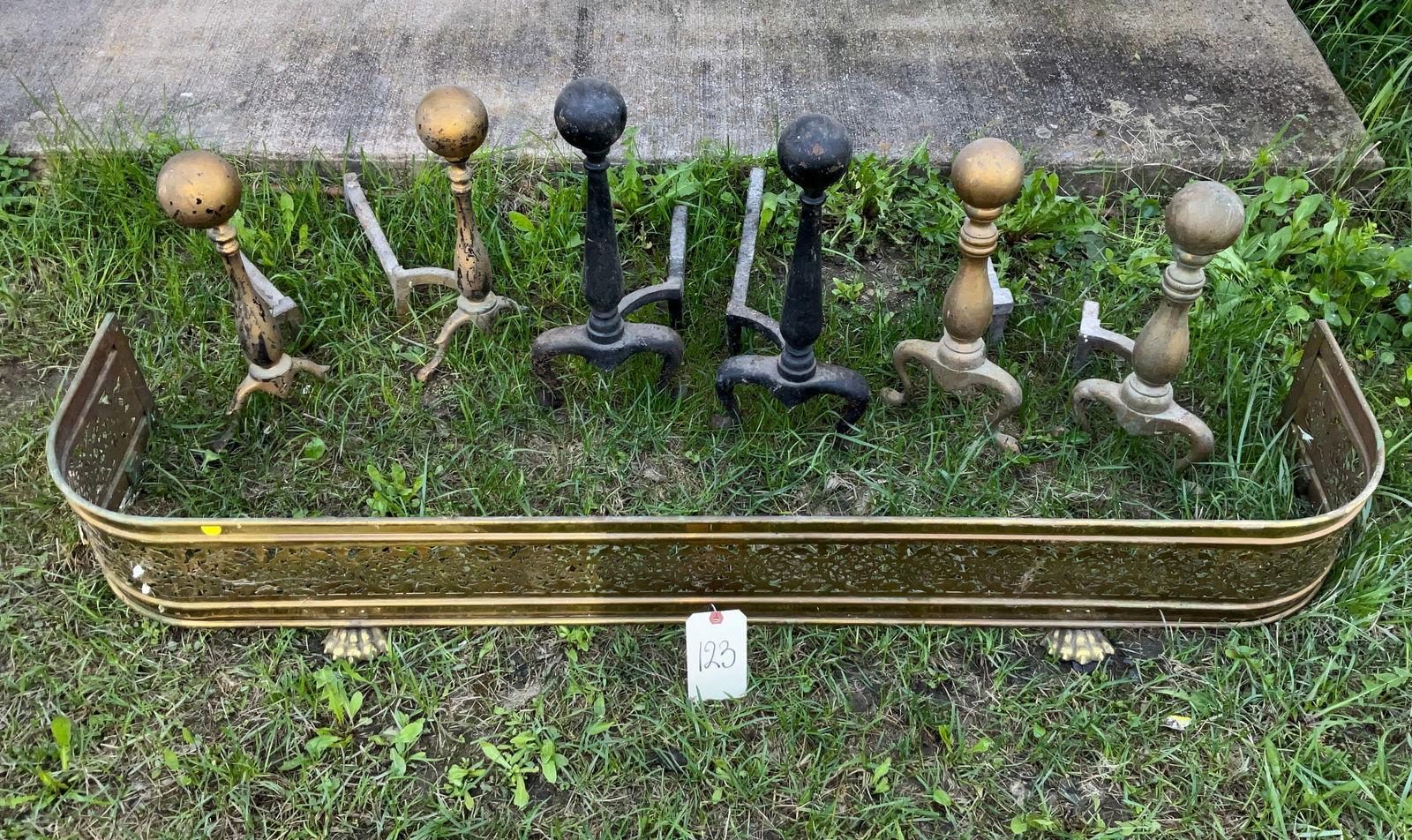 ASSORTED ANDIRONS AND BRASS FIREPLACE FENDER.: ASSORTED ANDIRONS AND BRASS FIREPLACE FENDER. FENDER MEASURES 54"L ANDIRONS AS IS, SEE PHOTOGRAPHS. Condition All property is sold in "as is" condition and all sales are final. Teel Auctions and its c
