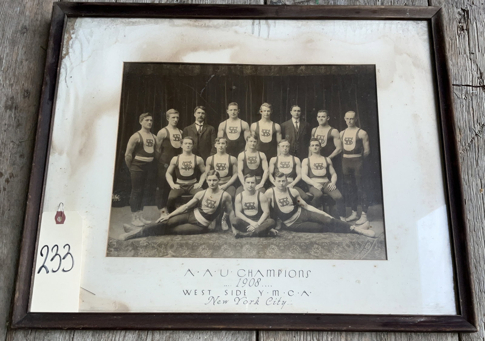 1908 TEAM PHOTOGRAPH AAU CHAMPIONS WEST SIDE NYC.: 1908 TEAM PHOTOGRAPH AAU CHAMPIONS WEST SIDE NYC. MEASURES 21" X 17". AS SHOWN. FRAMED. Condition All property is sold in "as is" condition and all sales are final. Teel Auctions and its consignor mak