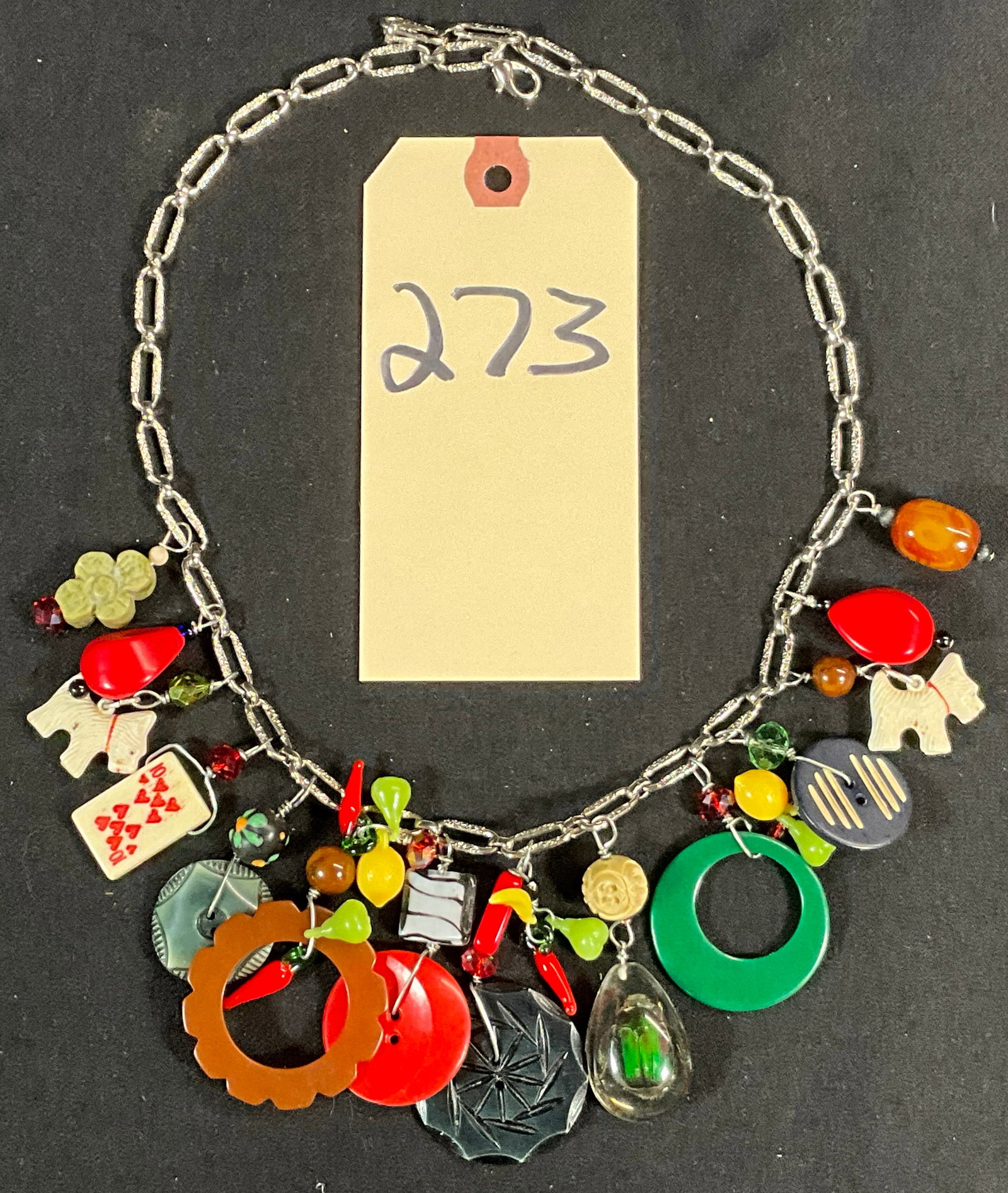 BAKELITE, CELLULOID, AND MORE 22" CHARM NECKLACE.: BAKELITE, CELLULOID, AND MORE 22" CHARM NECKLACE. Condition All property is sold in "as is" condition and all sales are final. Teel Auctions and its consignor make no representations or warranties, ex
