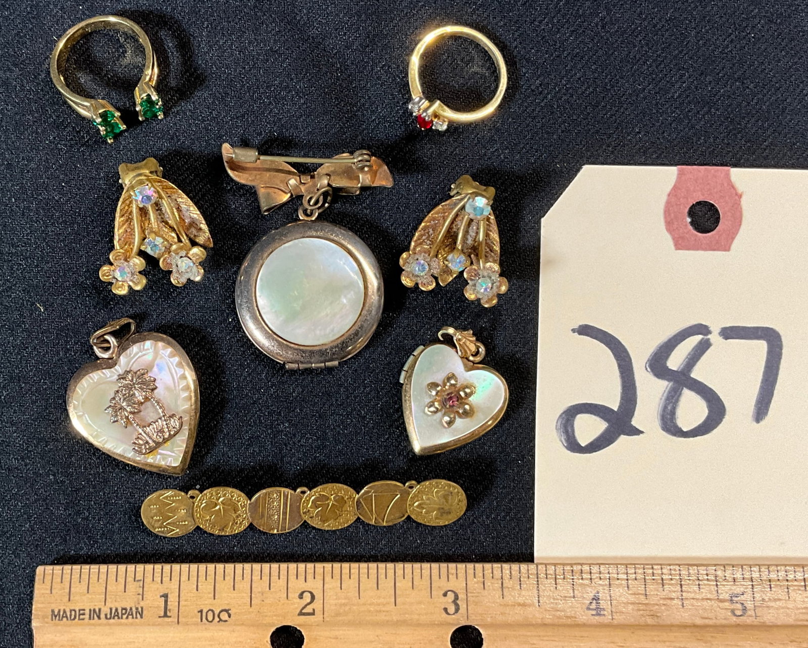 MOTHER OF PEARL AND MORE DECORATED LOCKETS, RINGS, AND MORE.: MOTHER OF PEARL AND MORE DECORATED LOCKETS, RINGS, AND MORE. 18K GOLD FILLED RING SIZES 5 AND 5.25, AUSTRIA EARRINGS, AND OTHERS. Condition All property is sold in "as is" condition and all sales are 