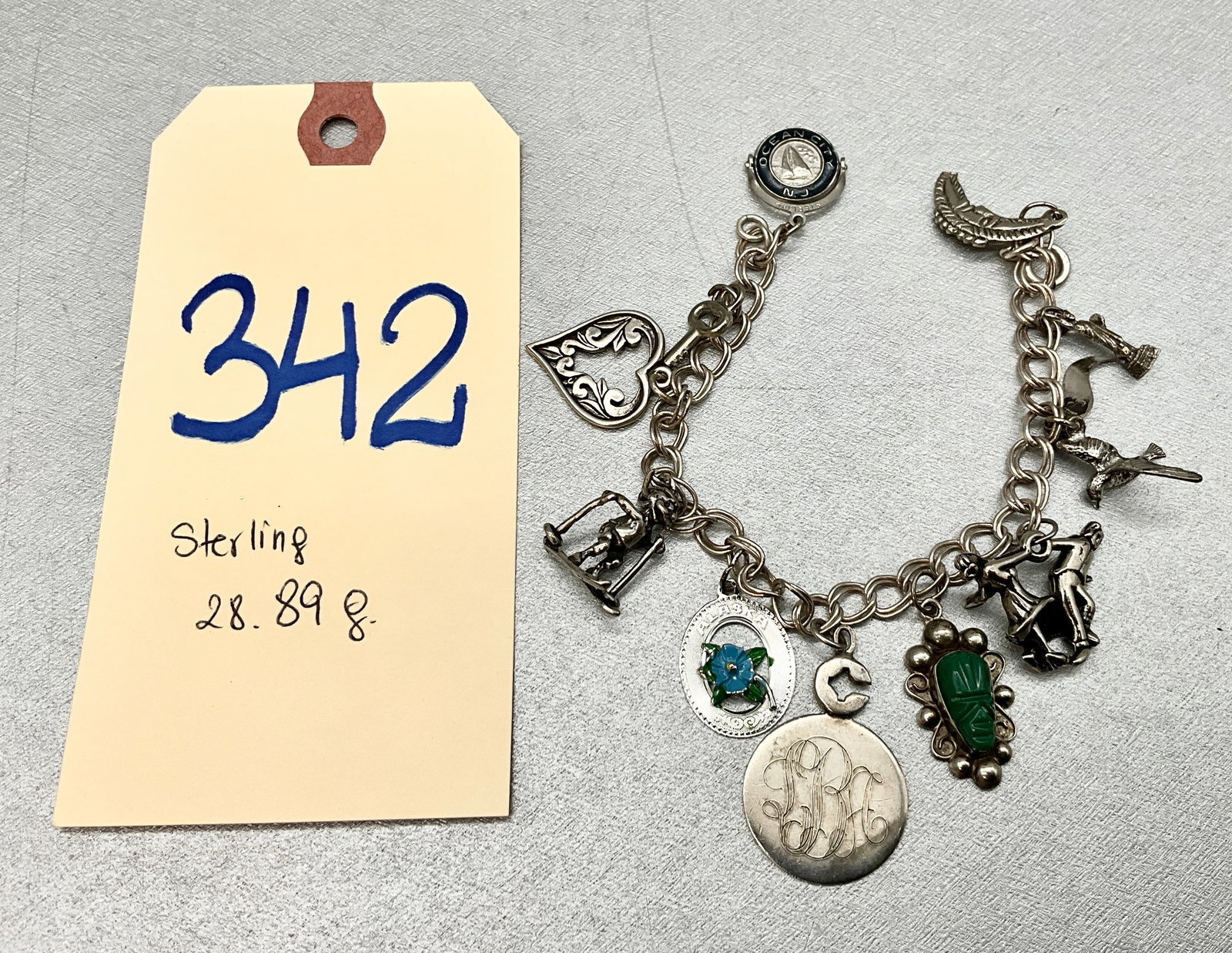 STERLING SILVER CHARM BRACELET, TOTAL 28.89 GRAMS.: STERLING SILVER CHARM BRACELET, TOTAL 28.89 GRAMS. Condition All property is sold in "as is" condition and all sales are final. Teel Auctions and its consignor make no representations or warranties, e