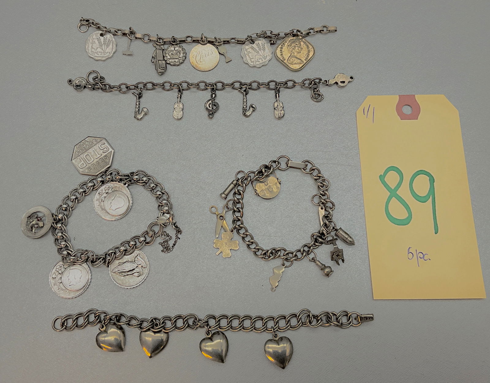 5 PC ASSORTED UNMARKED CHARM BRACELETS.: 5 PC ASSORTED UNMARKED CHARM BRACELETS. RELIGIOUS CHARMS, MUSICAL INSTRUMENT CHARMS, HEARTS, COINS, AND MORE. ONE BRACELET IS MARKED STERLING, HOWEVER, CHARMS ARE UNMARKED. OTHERS MARKED KENT, AND MOR