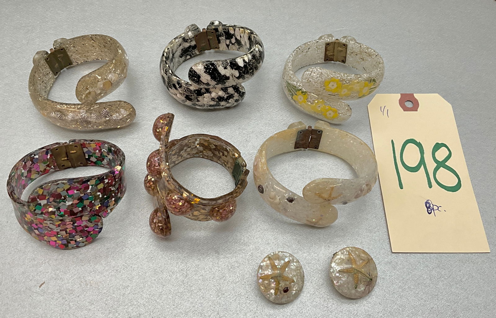 8 PC VINTAGE CONFETTI LUCITE HINGED CUFF BRACELETS AND EARRINGS.: 8 PC VINTAGE CONFETTI LUCITE HINGED CUFF BRACELETS AND EARRINGS. Condition All property is sold in "as is" condition and all sales are final. Teel Auctions and its consignor make no representations or