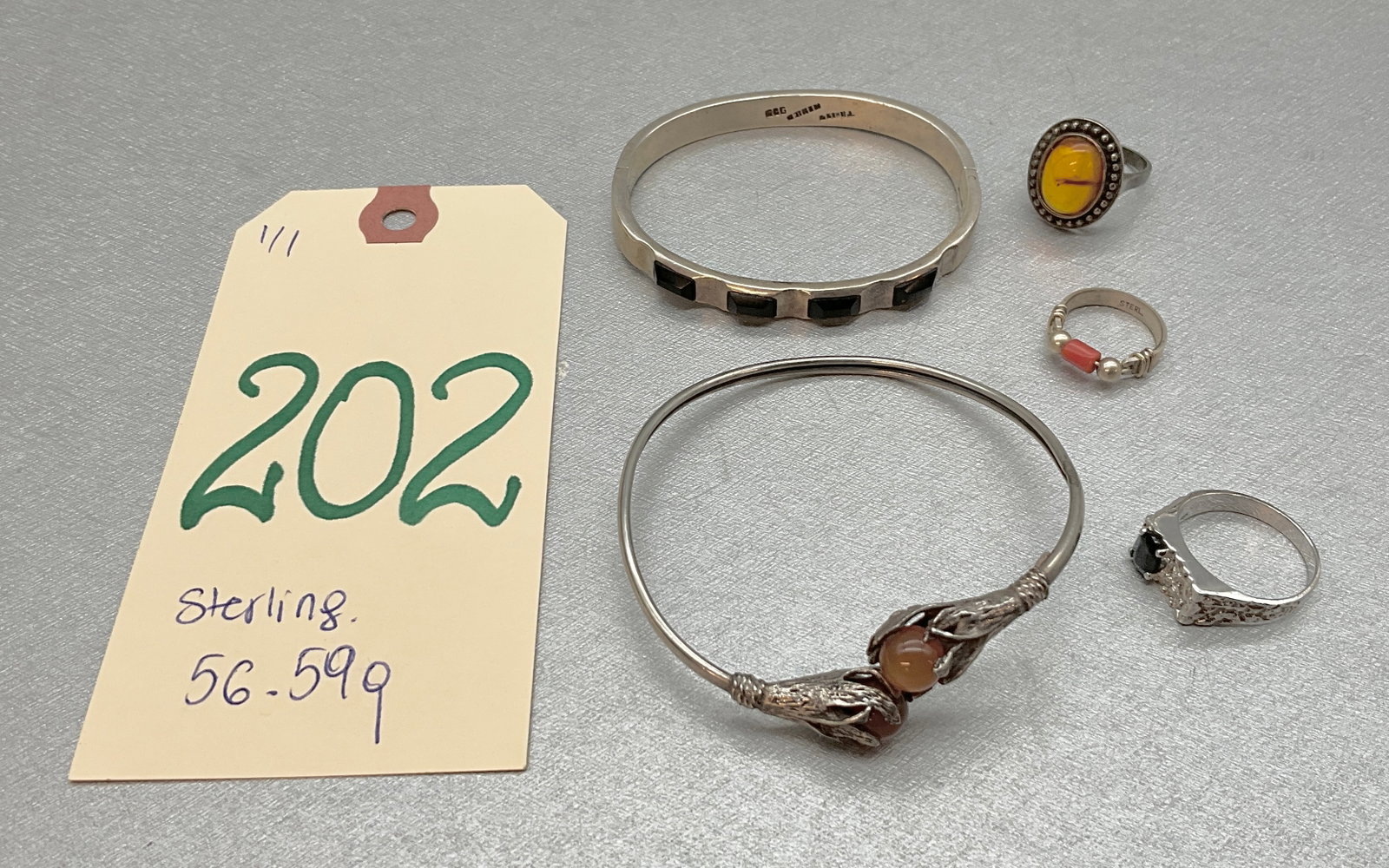 5 PC STERLING JEWELERY INCLUDING A TIGER EYE AND CORAL RING: 5 PC STERLING JEWELERY INCLUDING A TIGER EYE AND CORAL RING. TOTAL WEIGHT 56.59 GRAMS. RING SIZES 7, 9, AND 4 Condition All property is sold in "as is" condition and all sales are final. Teel Auctions