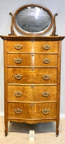 5 DRAWER TIGER OAK CARVED MIRRORED BACK HIGHBOY CHEST WITH BRASS DRAWER PULLS.