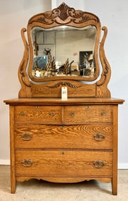 ANTIQUE CARVED OAK DRESSER WITH BEVELED GLASS MIRROR.