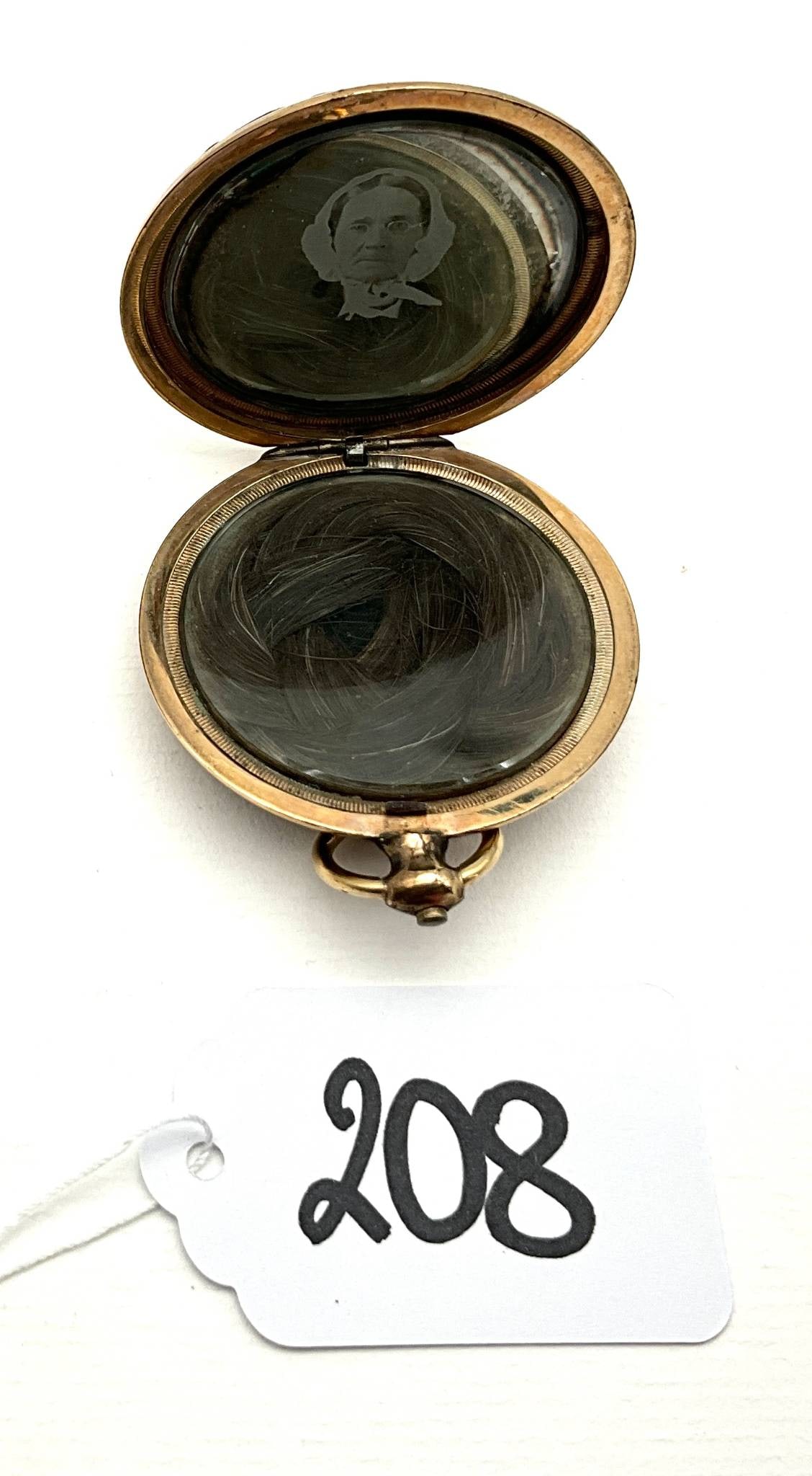 Gold-Tone Monogrammed Etched Locket with 1.75″ Diameter: Gold-tone round locket with a diameter of 1.75", featuring detailed etching on both the front and back. The front displays an intricate design with space for monogramming, while the back features a se