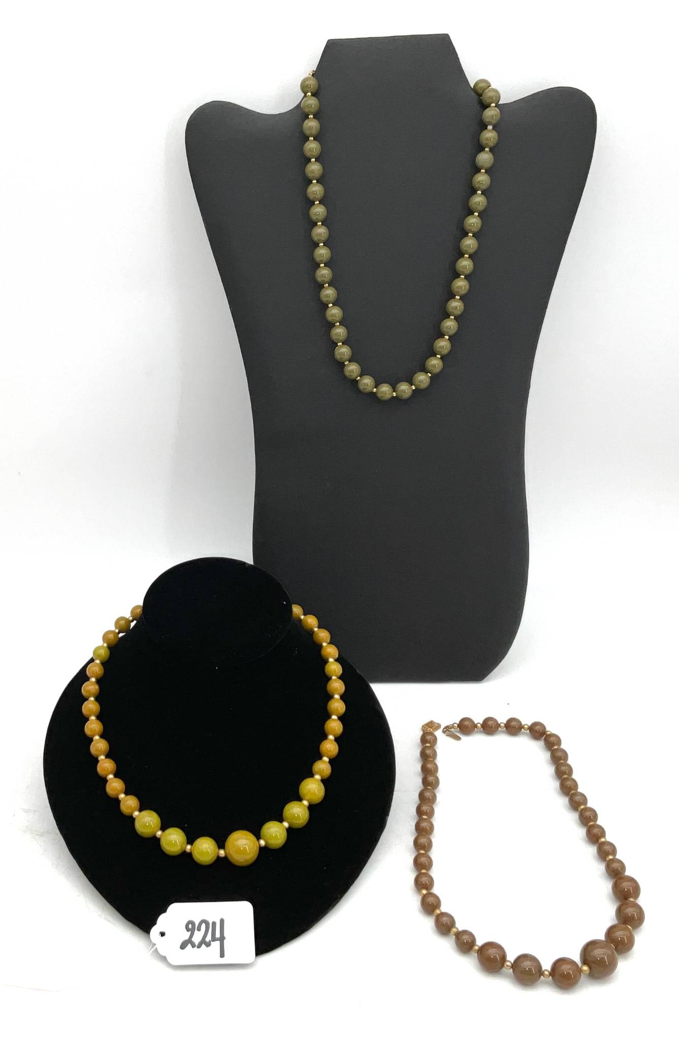 Three Bakelite Bead Necklaces, Approximately 17 Inches Long: Three Bakelite bead necklaces, each measuring approximately 17 inches in length. These necklaces feature beads in varying earthy tones: green, brown, and amber, each separated by smaller spacer beads.