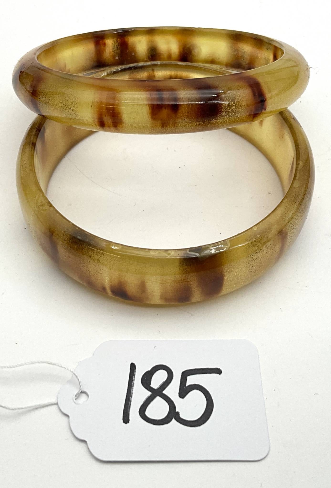 Vintage 2.5 Inch Diameter Bakelite-Style Bangles: Vintage bangles with a 2.5-inch diameter, featuring a classic mottled brown and amber design. Suitable for wear or collection, these bangles echo the timeless appeal of mid-20th century jewelry. Their