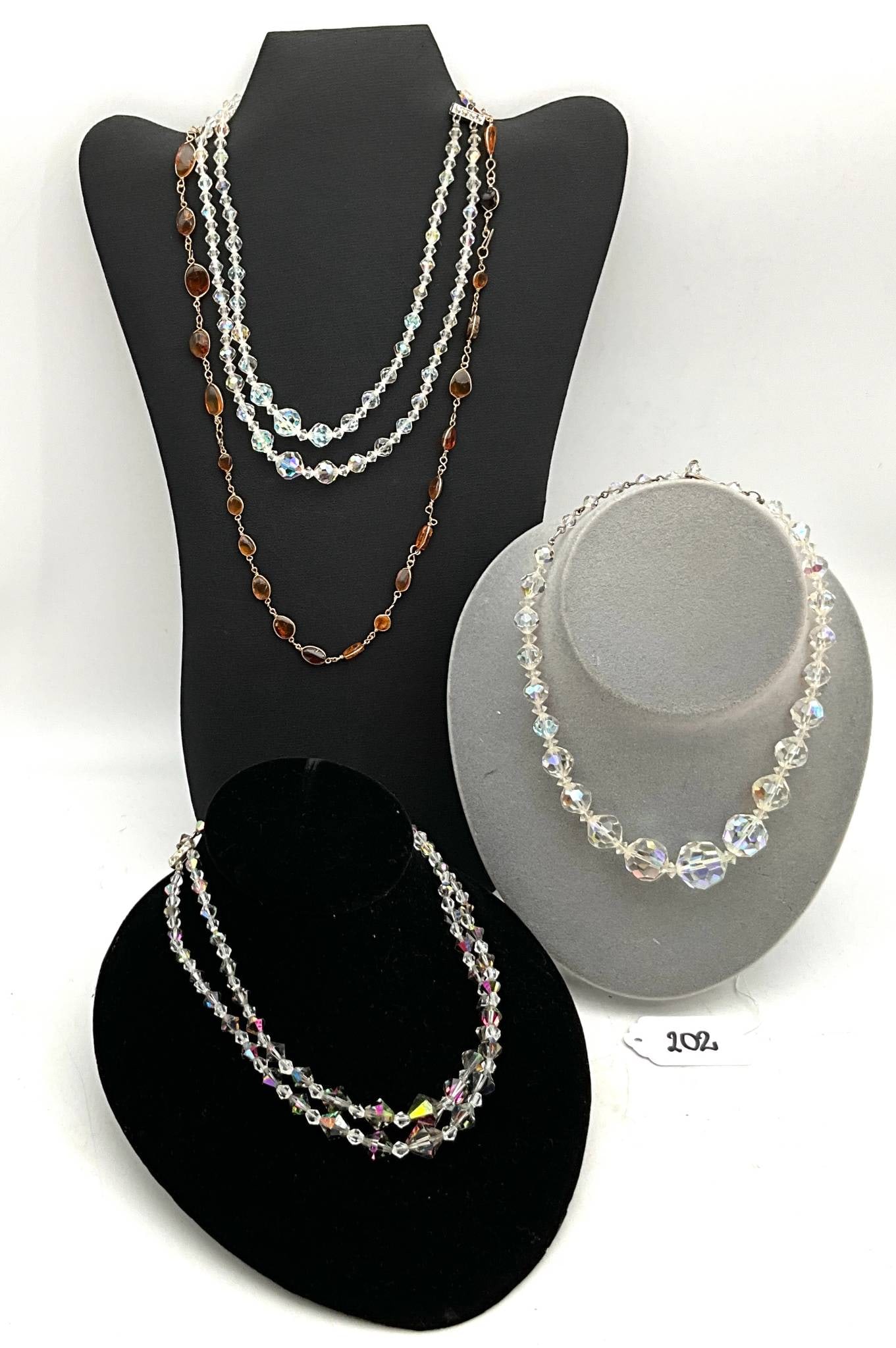 Crystal and Bead Necklaces: Necklaces measuring 10" to 20" in length. Includes multi-strand designs and single-strand designs in a variety of crystal and bead styles, featuring clear and colored elements. Displays are not includ