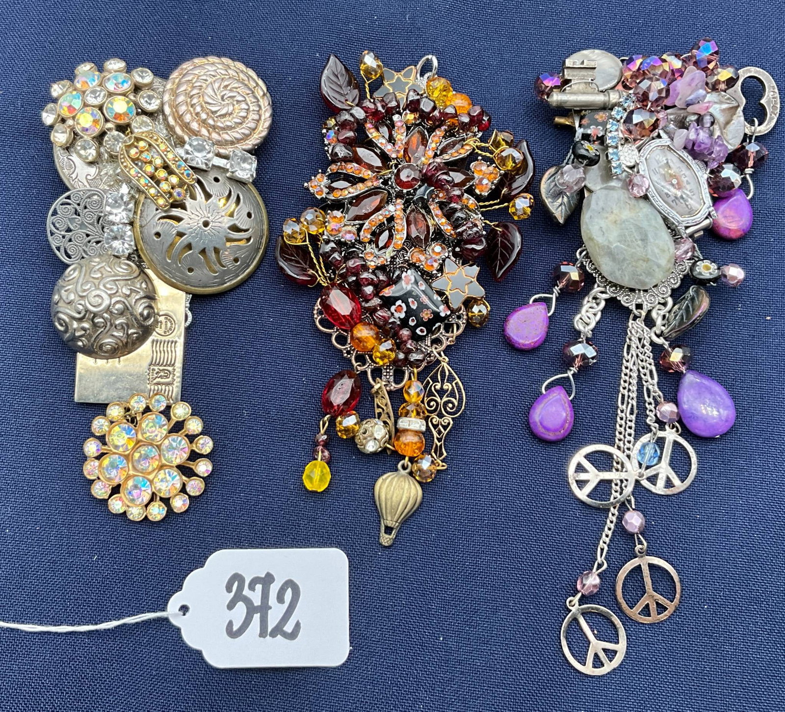 Sarah Jane Jewelry Lot of Three Multi-Charm Brooches with Mixed Materials: Three unique brooches from Sarah Jane Jewelry, each featuring layered charms, beads, and intricate designs. These pieces vary in size from 5.5 to 7 inches and showcase multi-material embellishments su