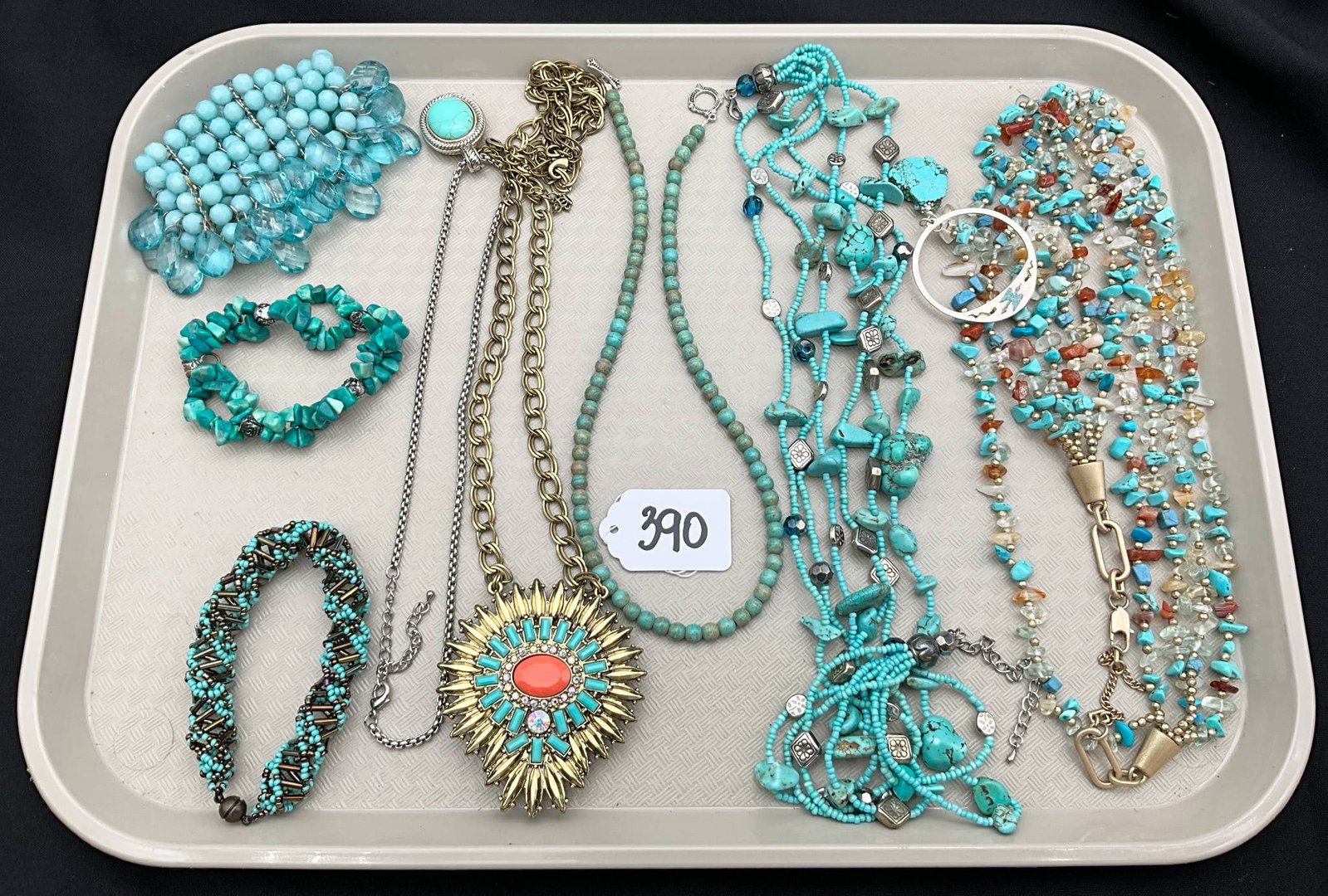 Turquoise-Colored Jewelry Including Necklaces, Bracelets, and Pendant: A curated selection of jewelry featuring turquoise-colored beads, stones, and metal elements. The collection comprises multiple necklaces, including beaded and multi-strand designs, bracelets in braid