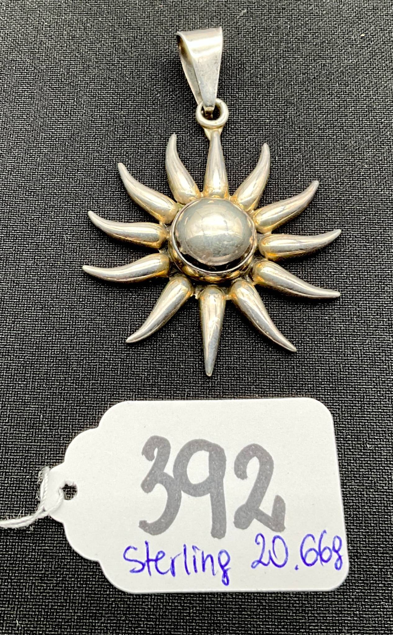 Sterling Silver Sunburst Pendant with Moonstone: Sterling silver sunburst pendant weighing 20.66 grams. Features a central bezel-set smooth moonstone, with sunray-style silver extensions accentuated by gold-tone details around the stone. Stamped "92