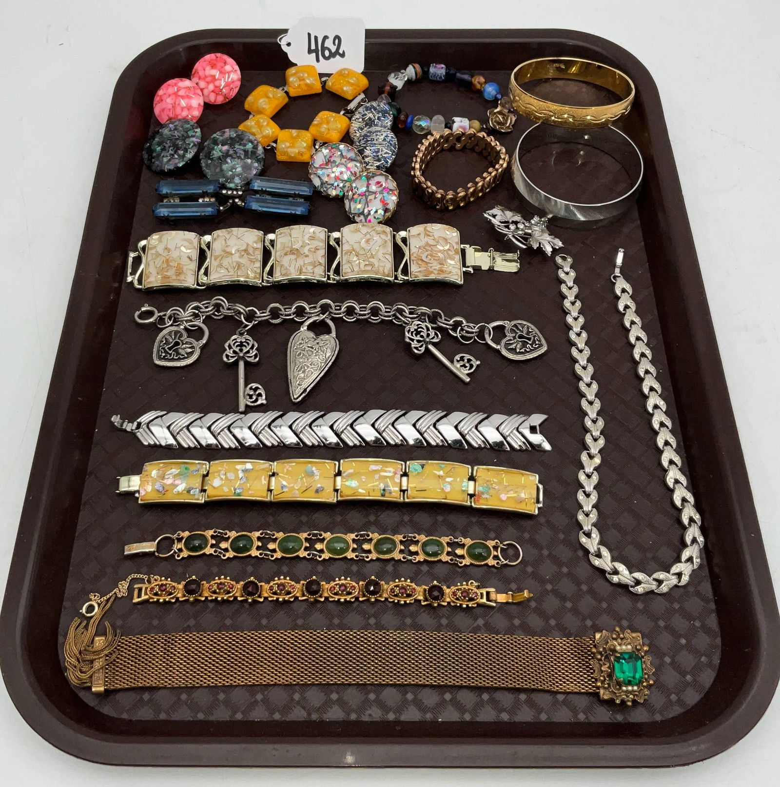 Jewelry Lot Featuring Pieces by Trifari, Monet, and More: Collection of jewelry including necklaces, bracelets, brooches, earrings, and bangles. Highlighted items include pieces by well-known makers such as Trifari and Monet. The lot includes gold-tone and s